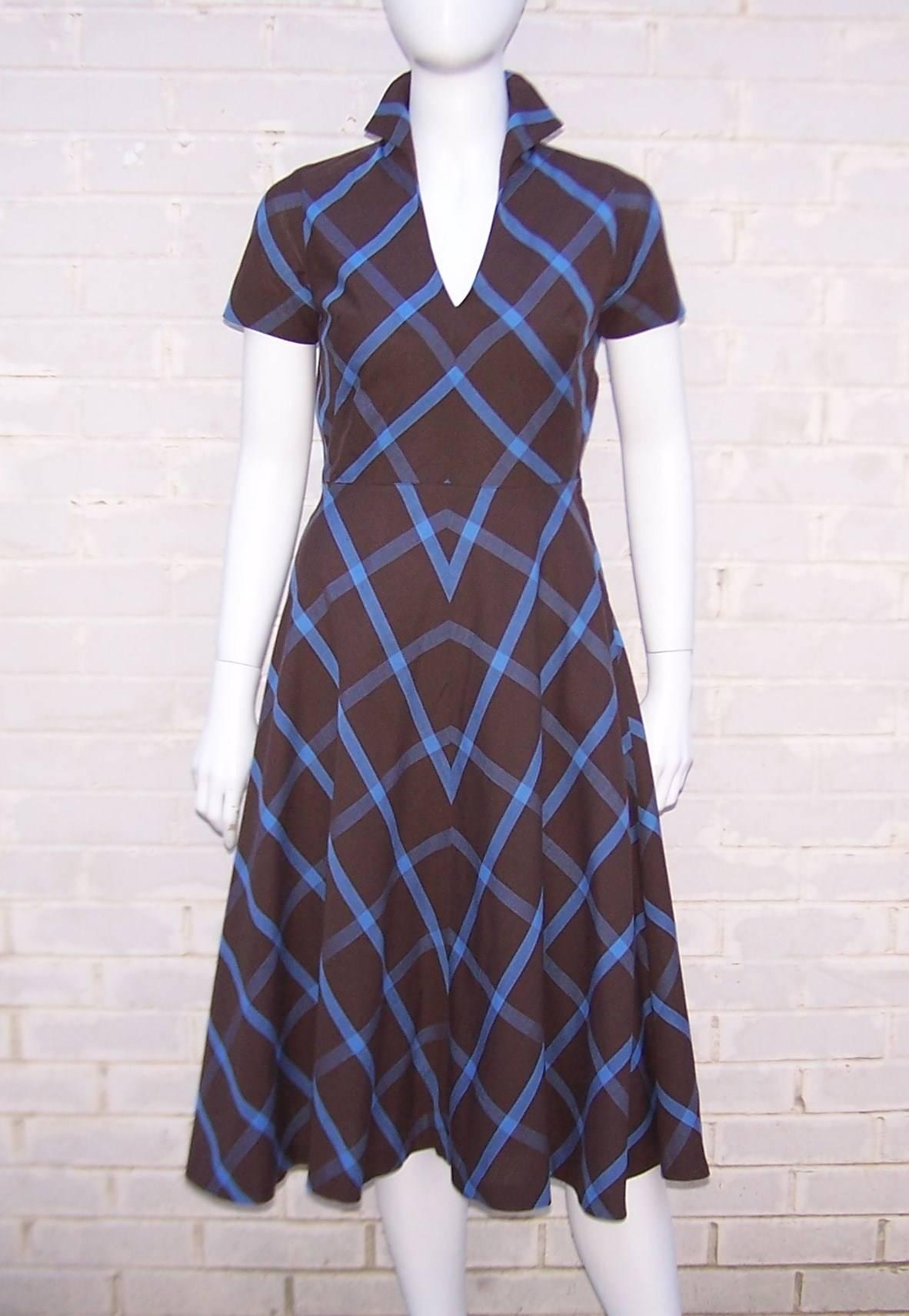 The contrast of periwinkle blue and chocolate brown makes this Peck & Peck cotton dress a stand-out.  It is a classic and simple 1950's cut with flippable collar, nipped waist and flared skirt.  Zips at the side creating a 'neat as a pin'