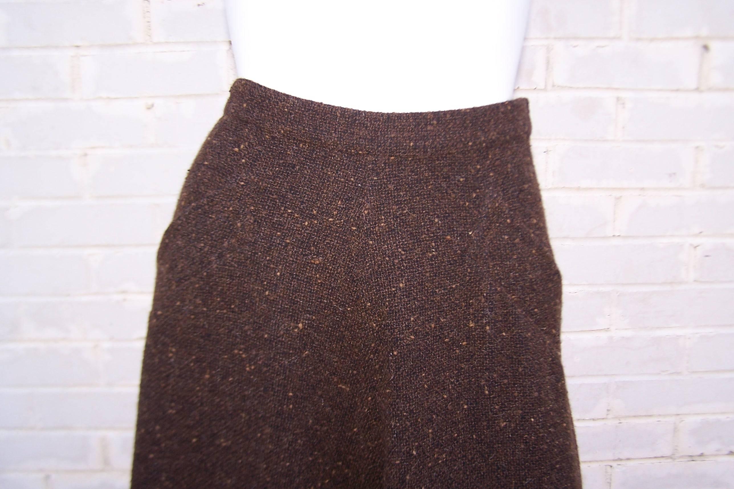 Great little skirt to pair with a sweater or cropped leather jacket from Yves Saint Laurent Haute Couture.  The autumnal brown fabric is a nubby tweed with hints of a black background and lighter colors in the mix.  The skirt zips and hooks at the