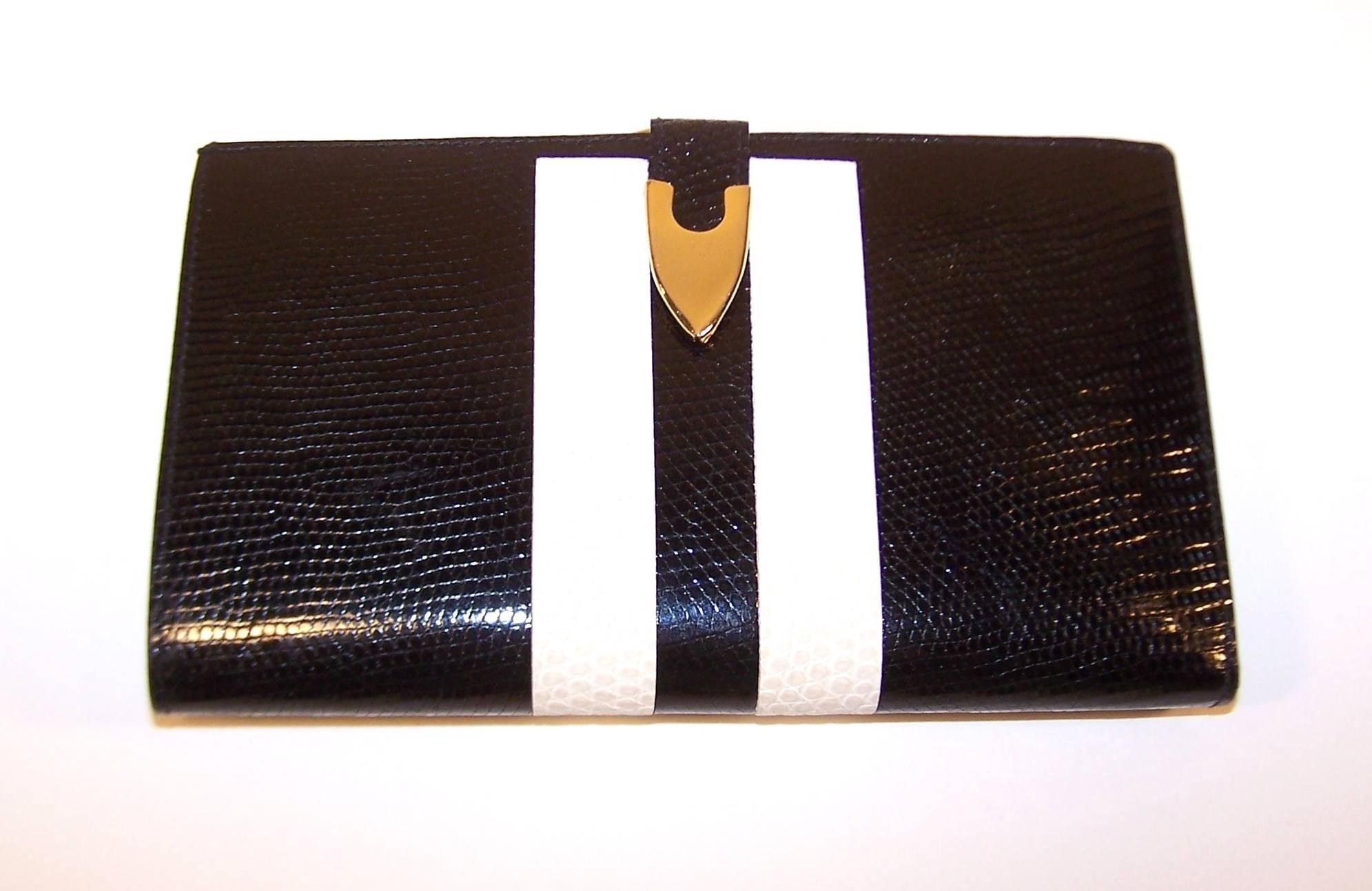 Snazzy two-toned black and white lizard skin wallet has fashion and functionality in one package.  This checkbook style design folds open to reveal pockets for bills, credit cards and checks.  It securely snaps closed with gold tone hardware and
