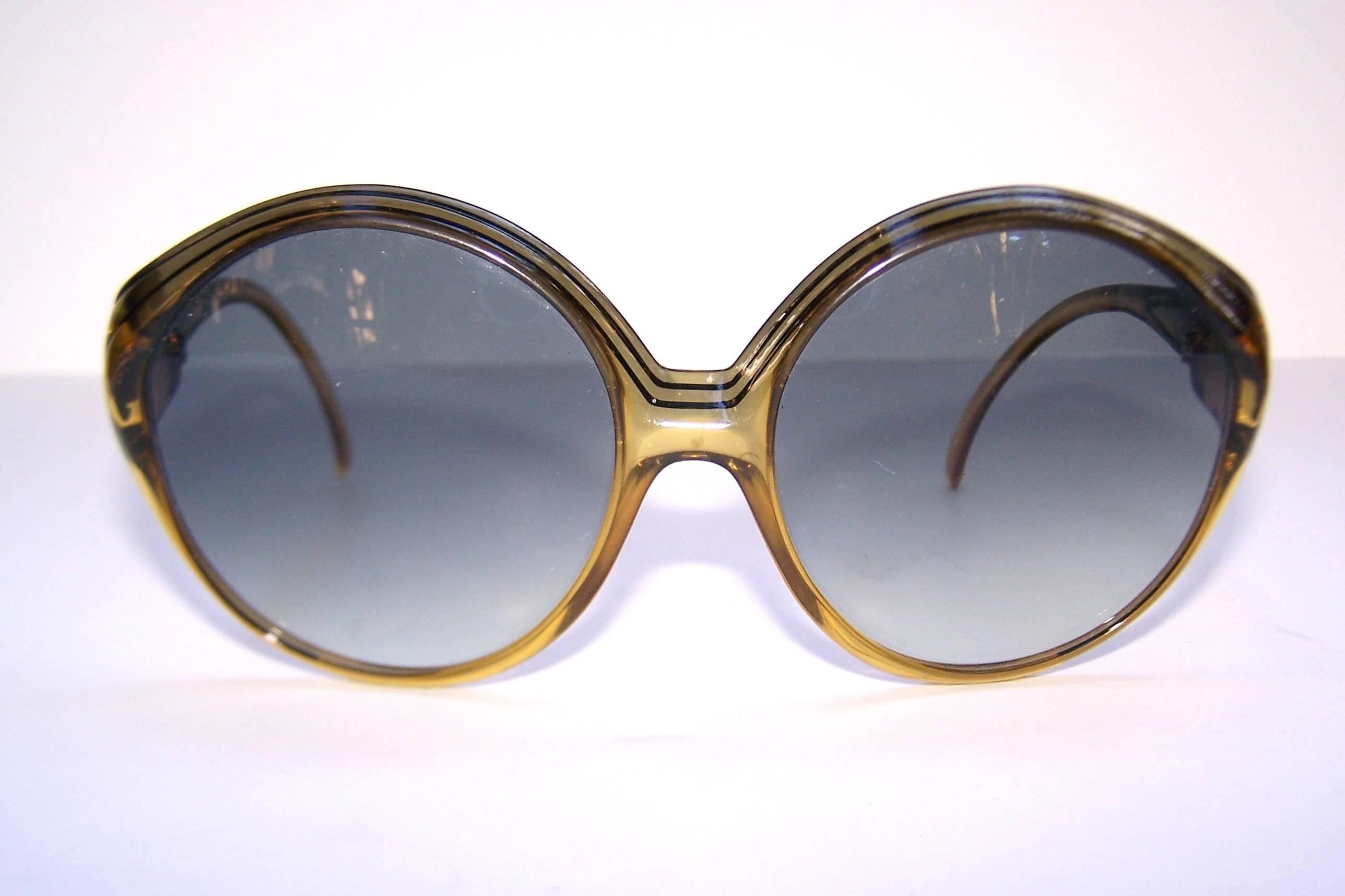 Large and in charge!  These oversized Christian Dior sunglasses manufactured by Optyl have a great 1970's period perfect look that mixes well as a modern fashion accessory.  The honey colored translucent frame has black striped details with an