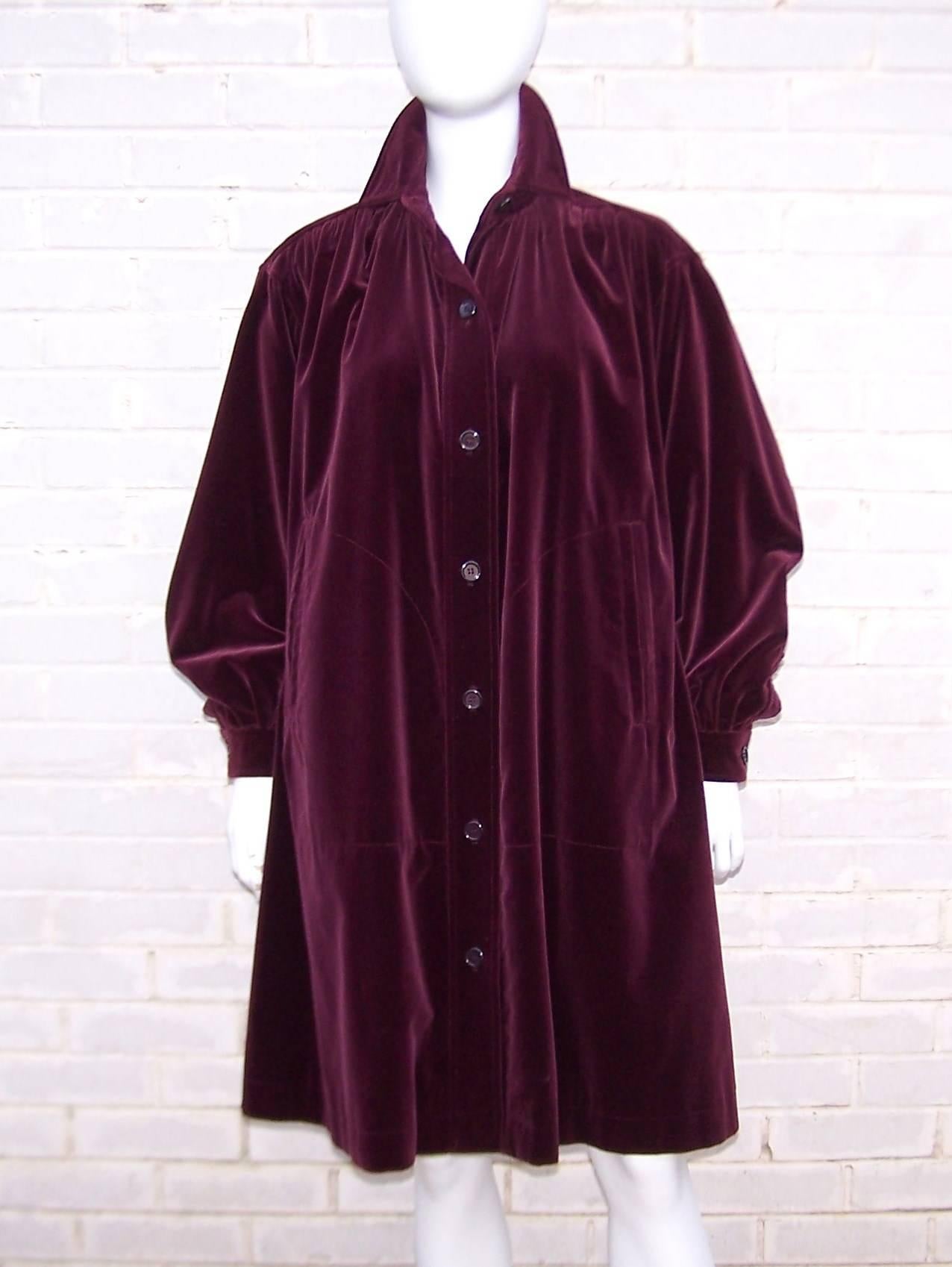 Lush...to the touch...to the eyes...every sensory perception is stimulated by this gorgeous Yves Saint Laurent coat!  The design starts with a rich ruby red heavy weight velvet fabric and moves onto a smock style construction with definition at the