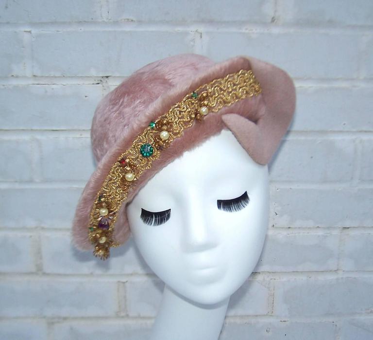 This precious 1940's hat by Atlanta milliner, Ella Buchanan Gunn, beautifully frames the face.  The pinkish mauve faux fur wool body is expertly crafted into a skull cap with asymmetrical upturned brim.  It is anchored with a crescent detail on the