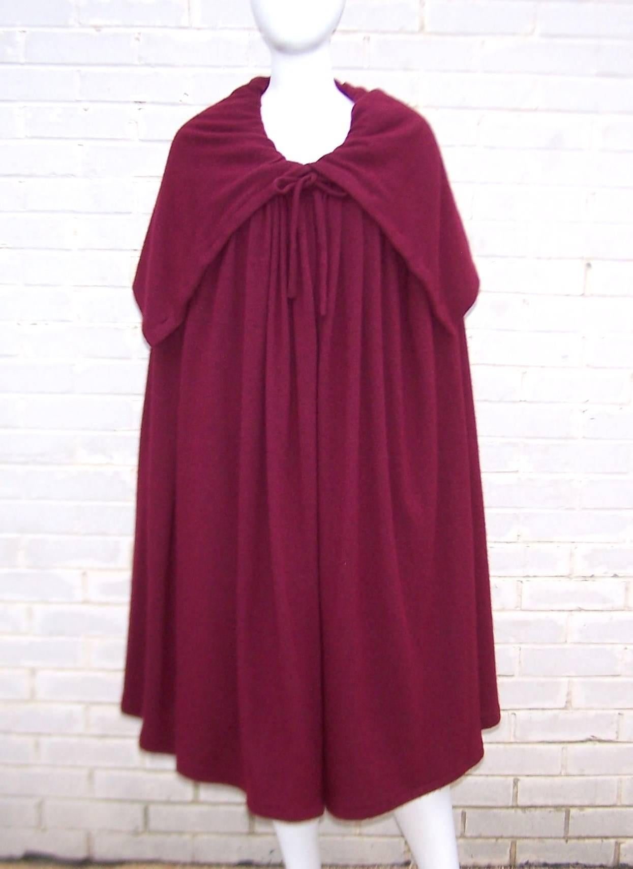 Oh the beautiful drama of a voluminous cape!  Especially when the cape is designed by Valentino Garavani in an aubergine red angora wool blend that drapes with all the comfort of a cozy wrap.  The cape ties at the neckline and buttons on the