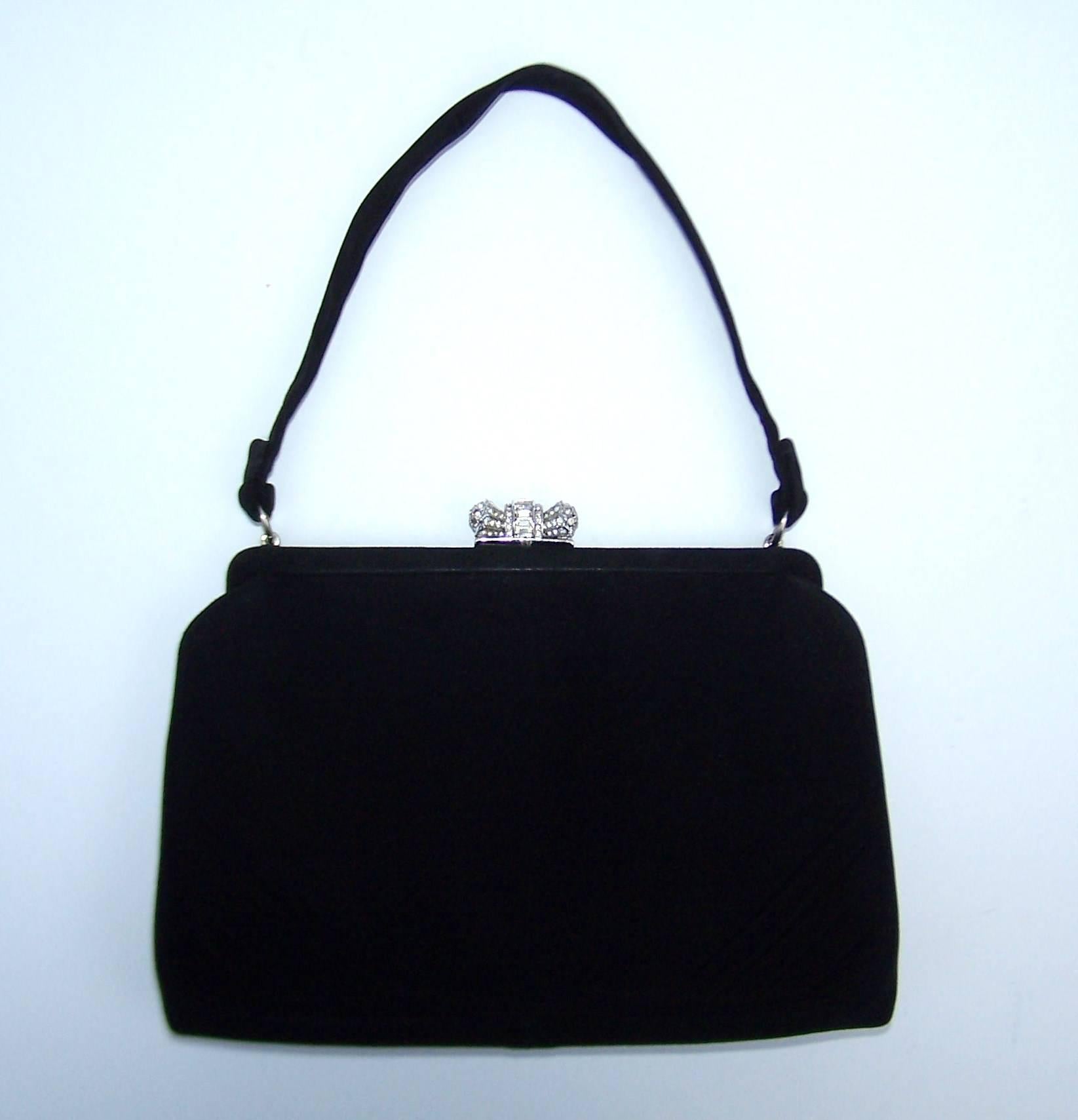 This classic 1950's top handled handbag by Coblentz is a perfect vintage accessory for a modern evening ensemble.  The black suede body is roomy enough for the essentials and the jewelry style rhinestone embellished closure adds just the right