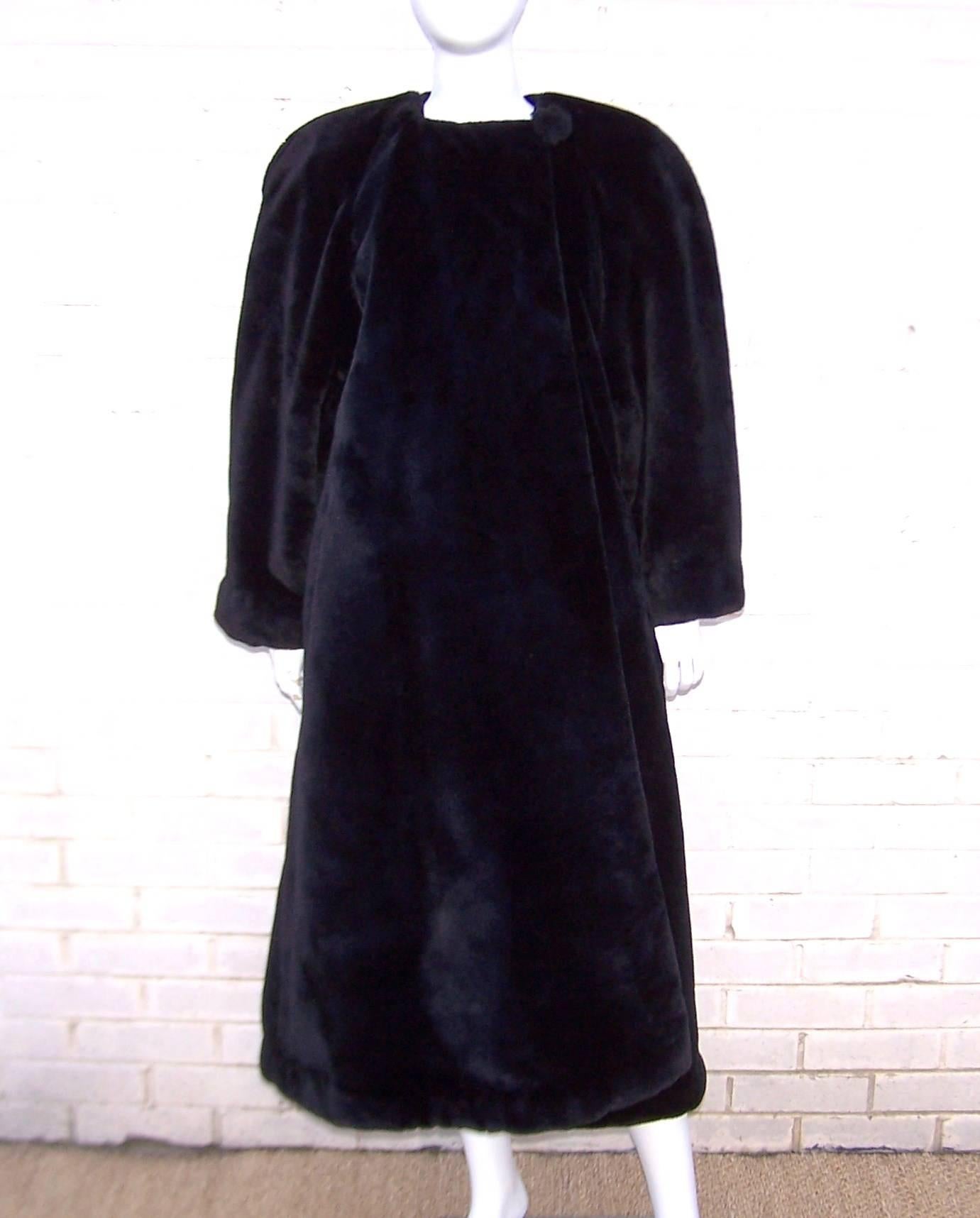 What a great bear hug of a coat!  From the late great Sonia Rykiel, this voluminous jet black faux fur coat has all the inspiration of a 1940's silhouette including broad shoulders and high drama. The coat buttons at the neck with a large faux fur