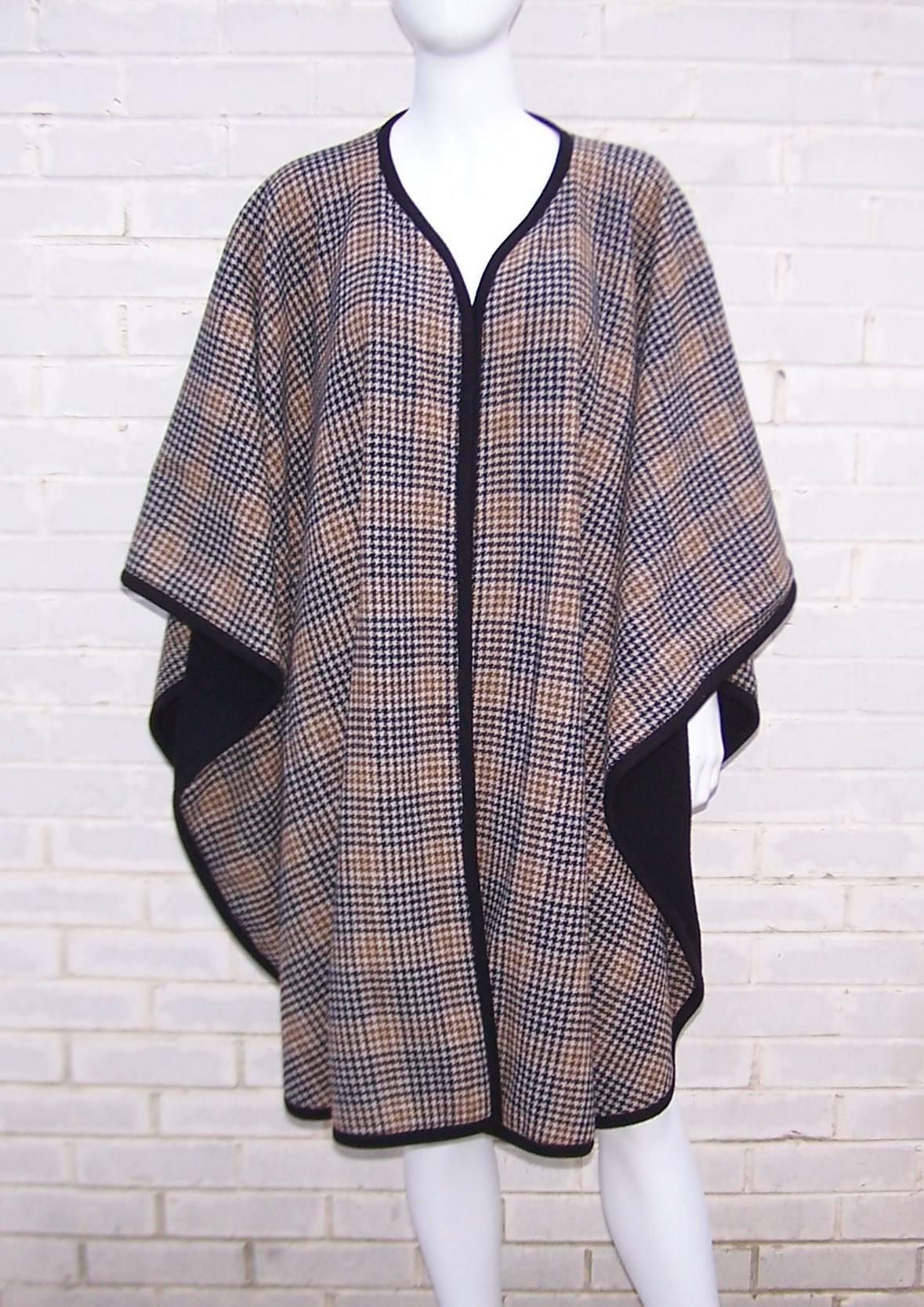 This wool knit cape is warm and cozy with all the classic charm of a Burberry style brown and black houndstooth pattern.  The versatile wrap is reversible and can be worn as solid black with just a hint of the houndstooth peeping through like a
