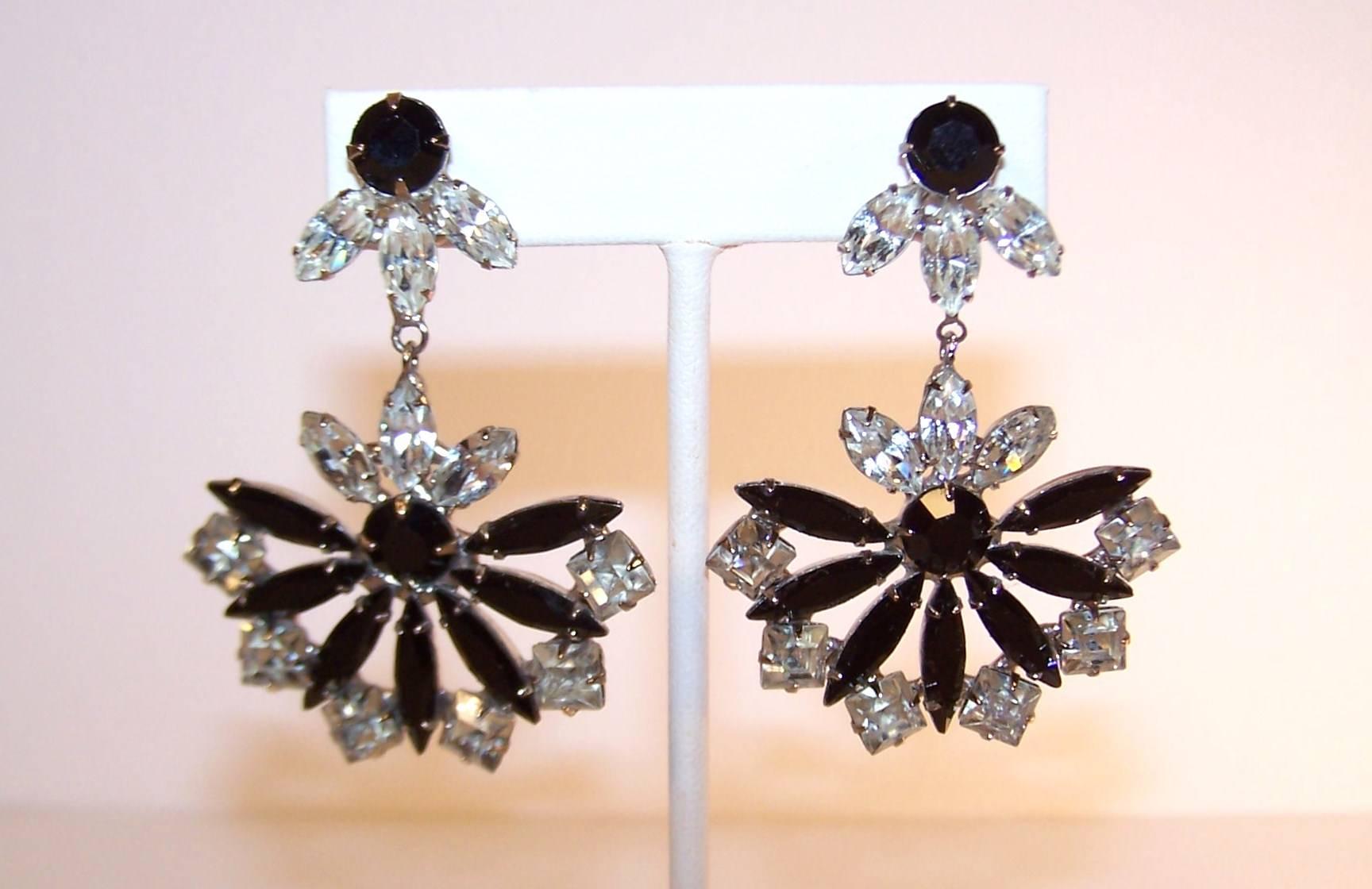 These Art Deco inspired earrings offer a great combination of two tone coloring and an eye catching fan shape.  The faceted black and crystal rhinestones are mounted in a silver metal setting with a comfortable clip on back.  The inverted fan shaped