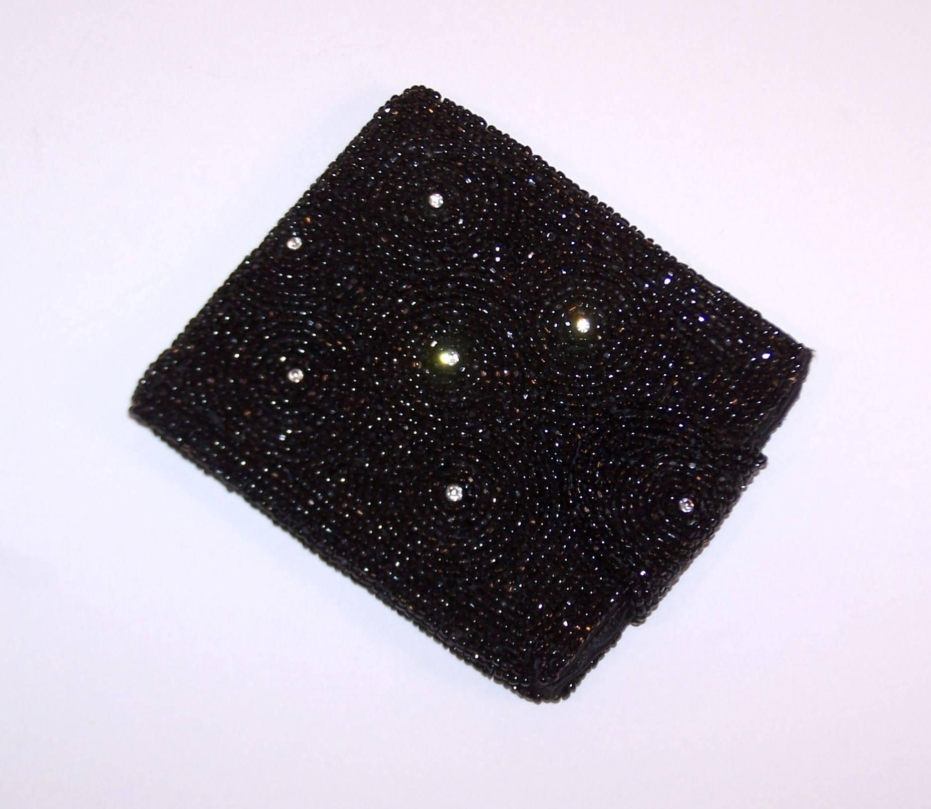 A beautiful evening handbag deserves an equally glamorous wallet.  This lovely Belgian wallet was made exclusively for Saks Fifth Avenue from black glass beads and faceted crystal rhinestones.  The black satin interior offers one pocket for cash and