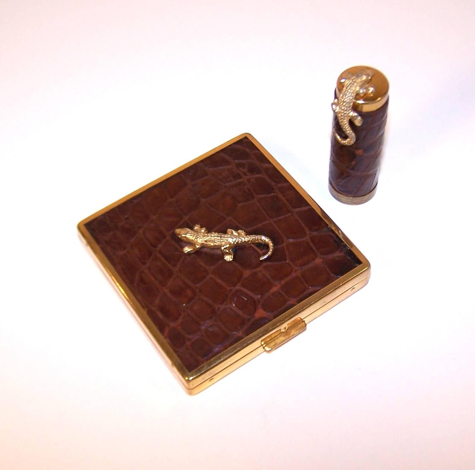 This whimsical 1950's alligator adorned set is by Ciner, an American costume jewelry company that has produced high quality accessories since the 1930's.  Both the gold tone mirrored compact and matching lipstick are covered in embossed brown