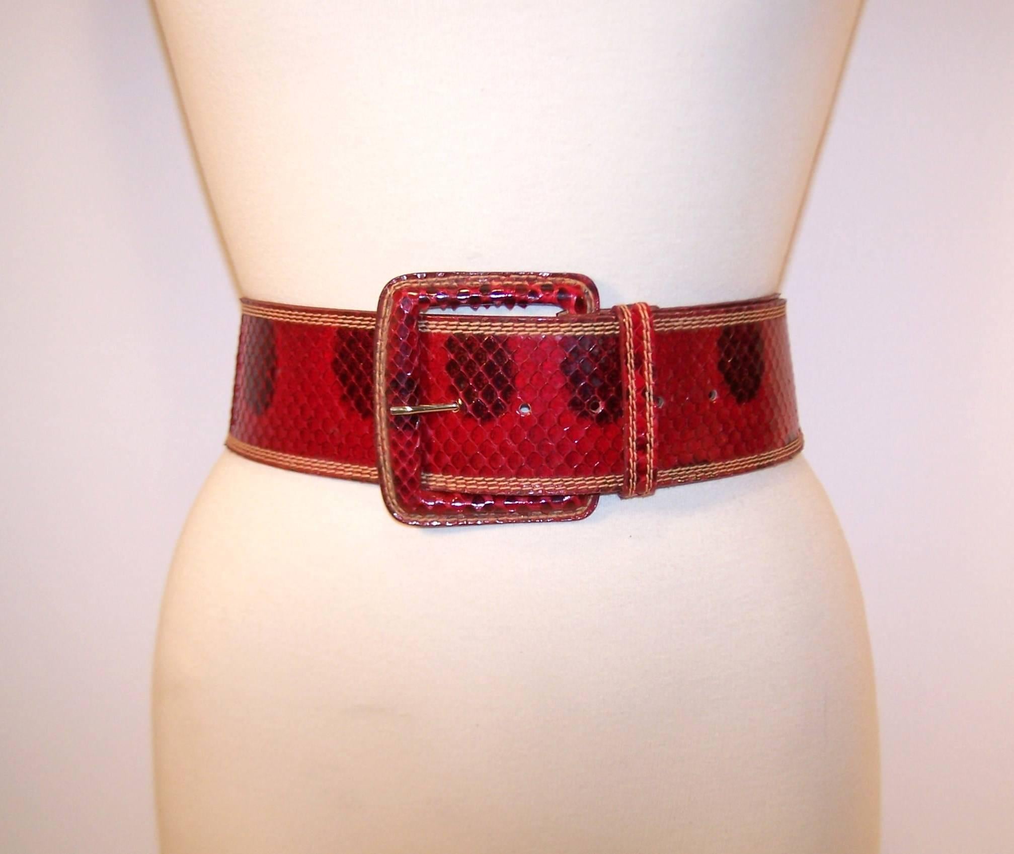 Cinch it in style with this Carlos Falchi red and black snakeskin belt.  The wide belt and squared buckle make for a perfect focal point to add structure and a finishing touch to your ensemble.  Measures 2.5