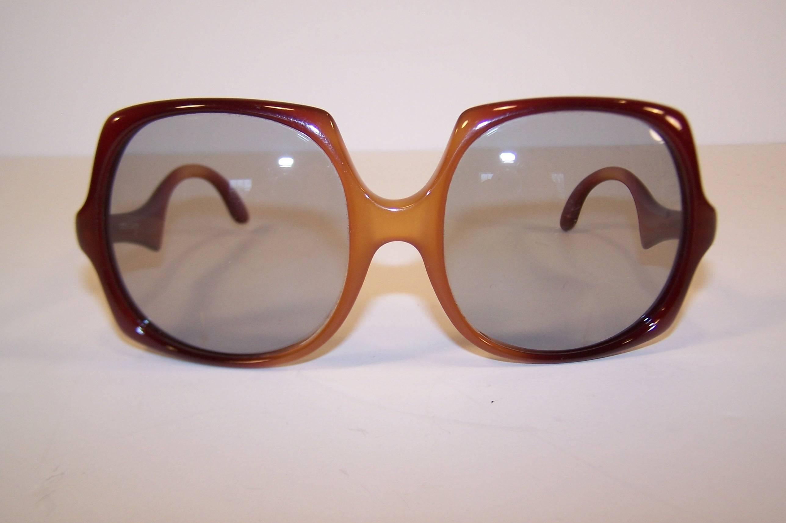 Square but far from 'square'!  These 1970's oversized mod sunglasses from Optyl Design feature a creamy caramel frame with light gray lenses.  The sculptural arms have a swoopy shape that provides an additional design element.  Optyl also produced