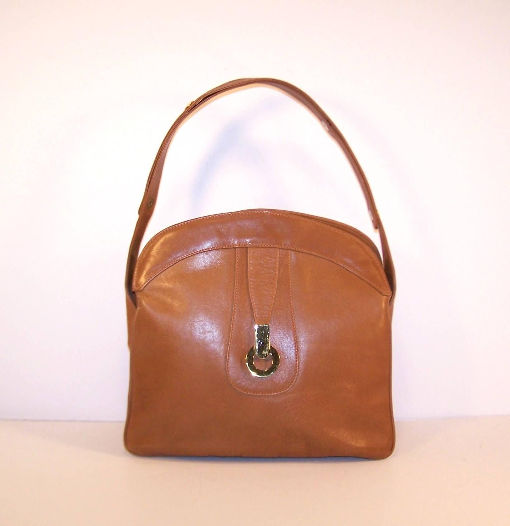 What a classic 1970's handbag with the quality of timeless style.  The versatile cognac color leather is accented with chunky gold tone hardware and an adjustable strap allowing for a quick change from top handle to shoulder strap.  The accordion