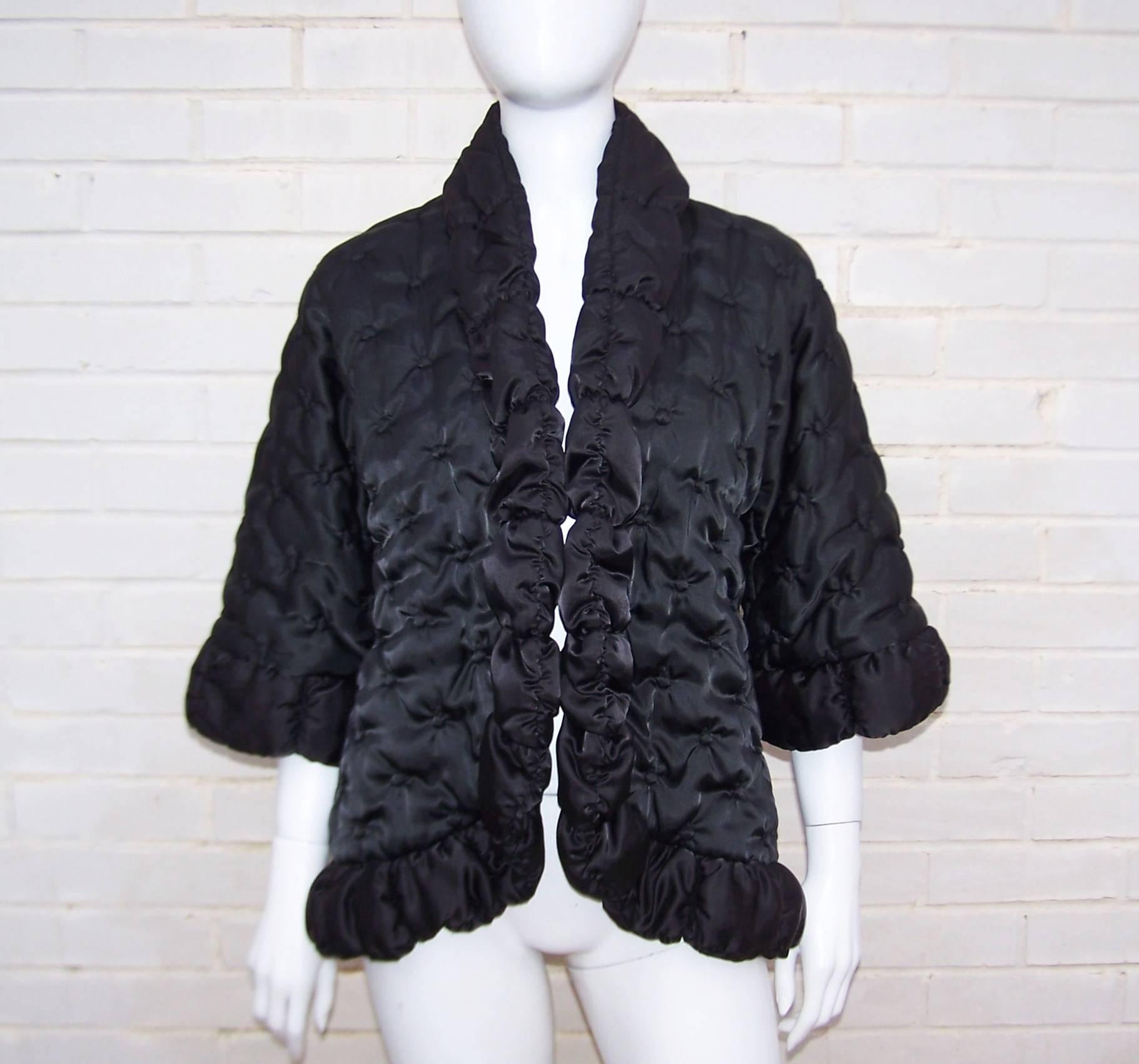 Wrap up in style with this Odette Barsa black quilted bed jacket which is stylish enough for evening wear.  The rollback collar, cutaway hemline and bell sleeves lends the silhouette an Asian style.  The quilting cleverly resembles tufted buttons. 