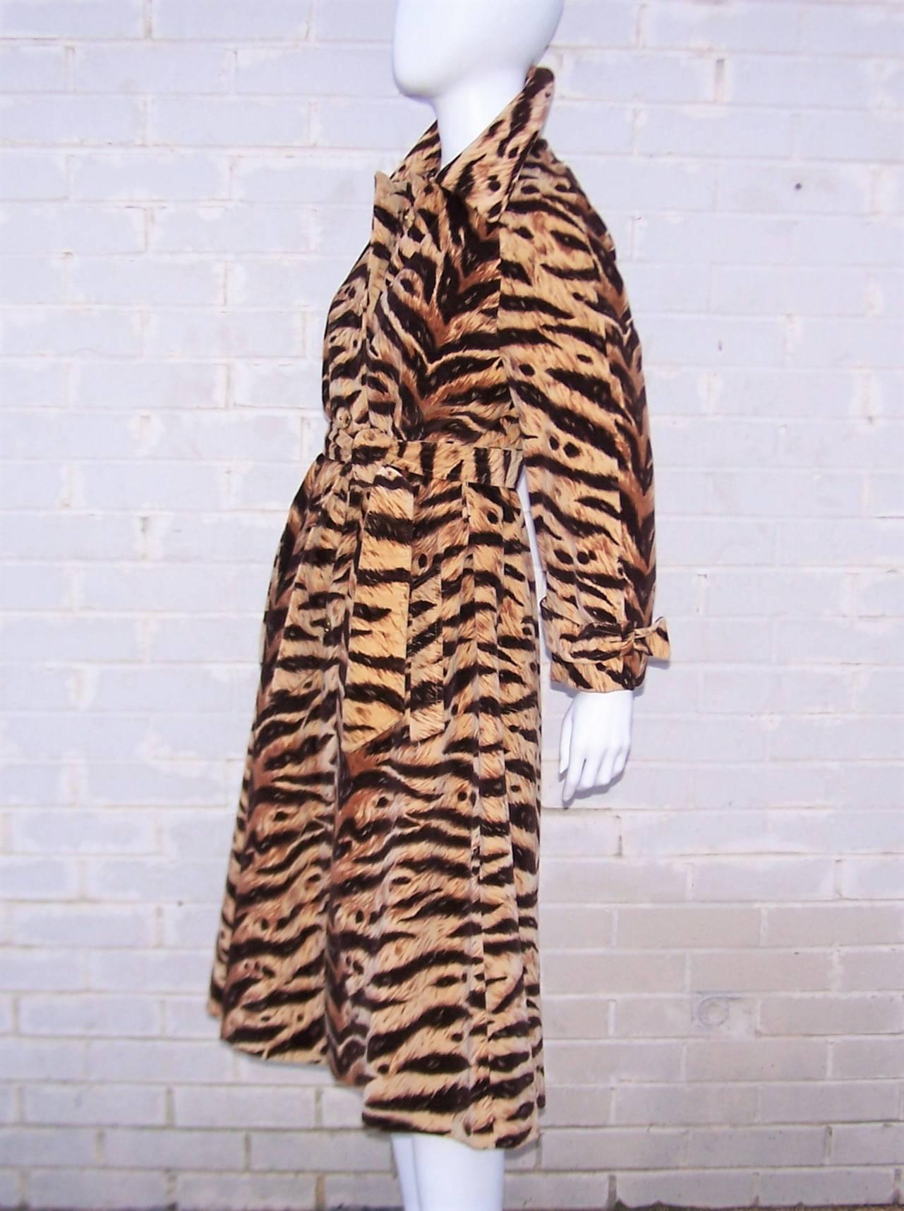 Channel your inner wild child with this 1970's Count Romi 'all-weather' trench coat.  The vibrant tiger print is so realistic that only touch gives away the velveteen truth.  It buttons up the front with coordinating fabric and gold tone buttons
