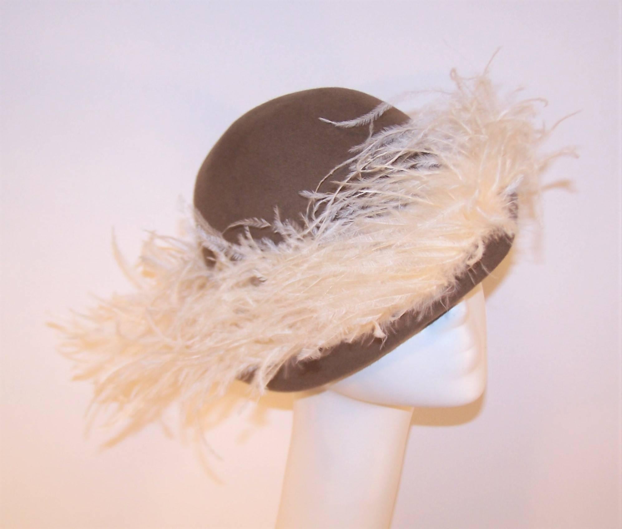 Look like a modern rendition of a musketeer in this 1970's Italian made hat by David.  The neutral taupe wool body has a furled brim whimsically embellished with ostrich plumes.  It's enough to tickle your fancy!  The hat is in excellent