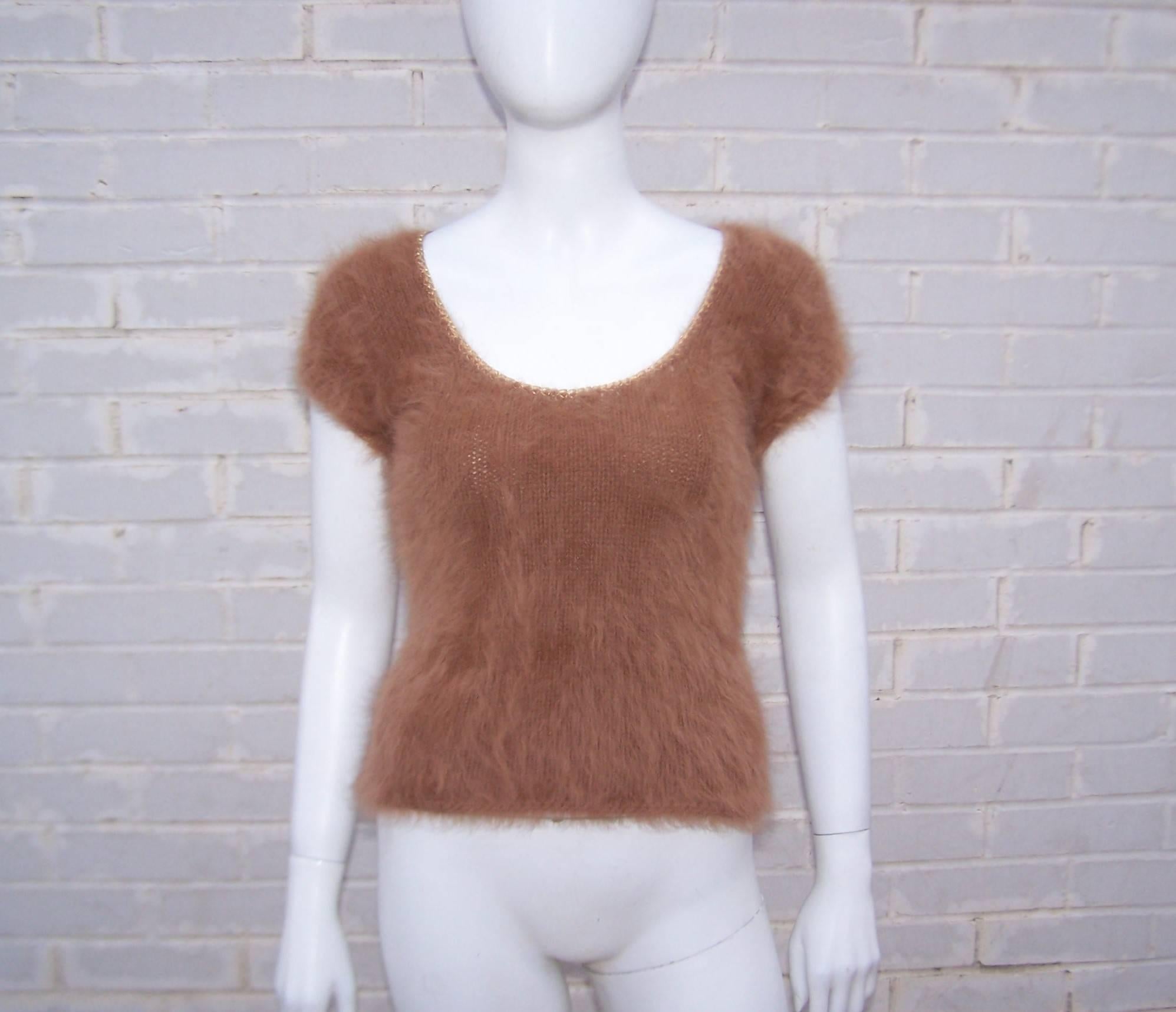 Get prepared to be touched!  This 1970's caramel color angora sweater by Cheryl Baron is irresistible.  The t-shirt style shape features cap sleeves, a scoop neck and easy pull on construction.  The neck and sleeves are trimmed in a gold braid which