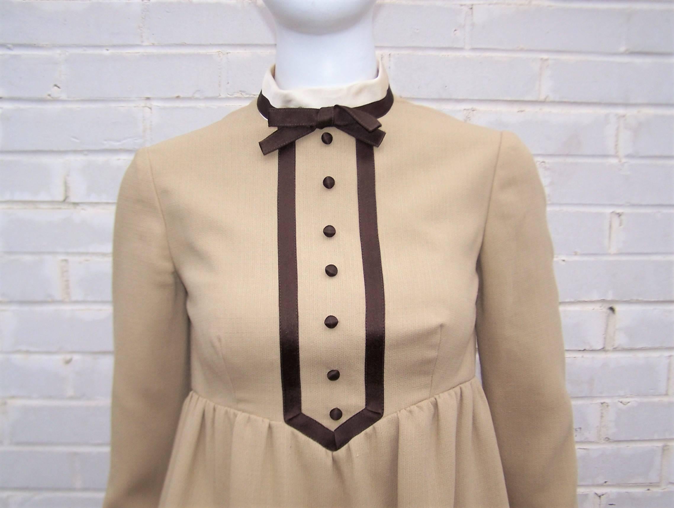 This 1960's Geoffrey Beene design is the epitome of girlish charm.  The comfortable beige wool blend fabric is accented by ivory and brown satin details at the neck and cuffs.  It zips and hooks at the back with an interior grosgrain waistband and