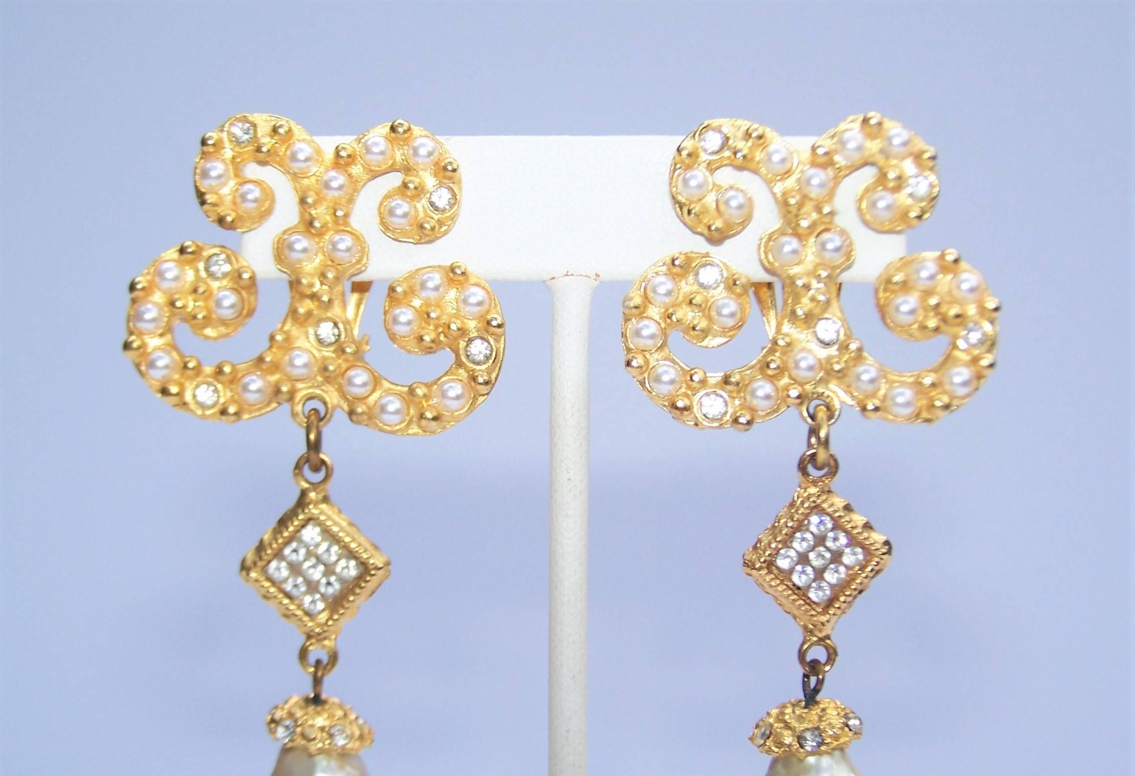 Glamorize your look with these 1980's goldtone dangle earrings embellished with faux pearls and crystal rhinestones by Gerard Yosca.  Mr. Yosca is known for his high quality artisan jewelry and continues to design beautiful pieces today.  The base