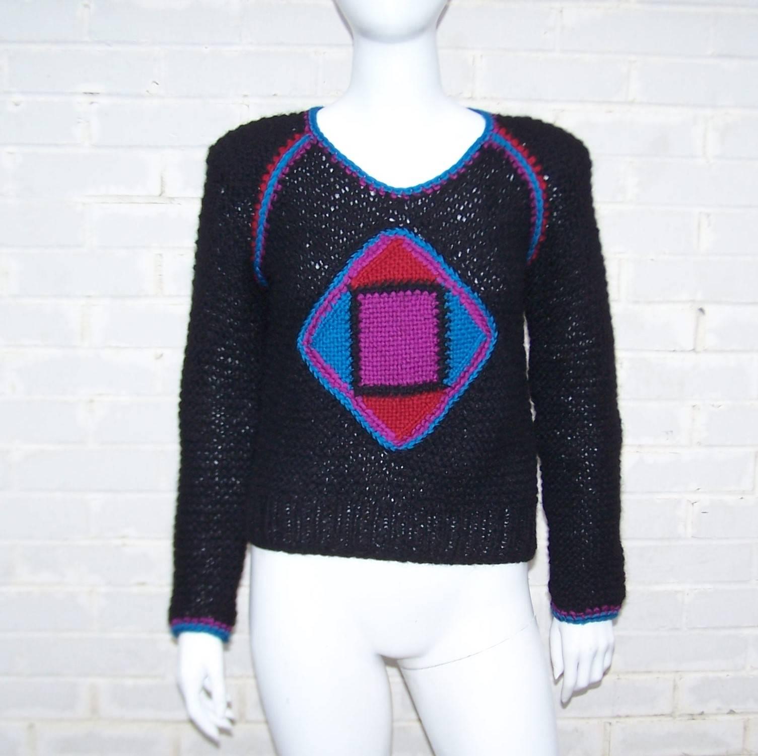 This cutie will take you from the cold days of Winter into the warm-up of Spring with a cozy design and vibrant colors.  The black hand knit wool sweater is accented with sporty graphics in contrasting colors...electric blue, purple and cherry red. 