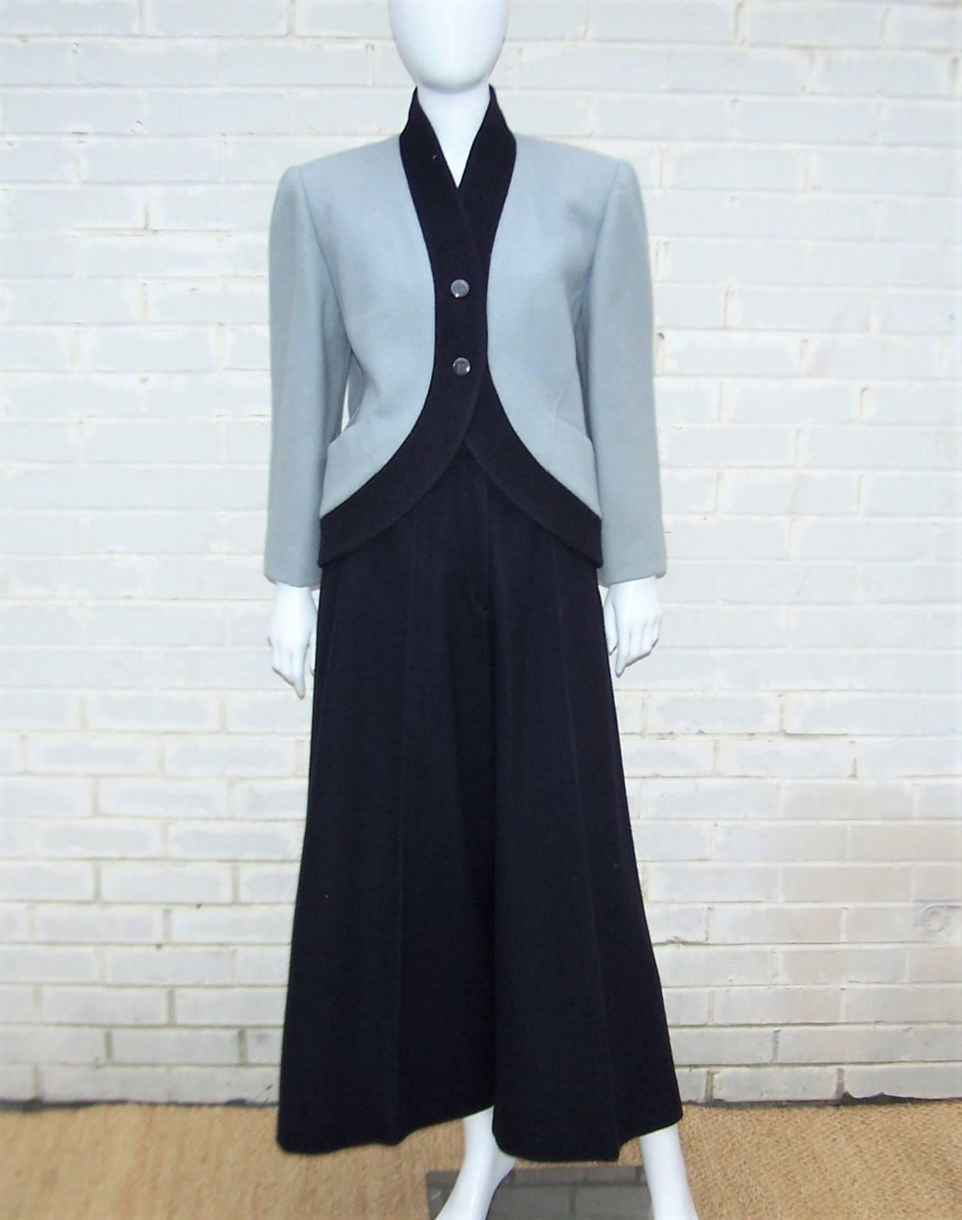 There is something decidedly exotic about this 1980's Karl Lagerfeld wool pant suit.  The boxy jacket with a cutaway button front opening is a dove gray trimmed in midnight blue.  The molded strong shoulder line is an expert mix of a nostalgic