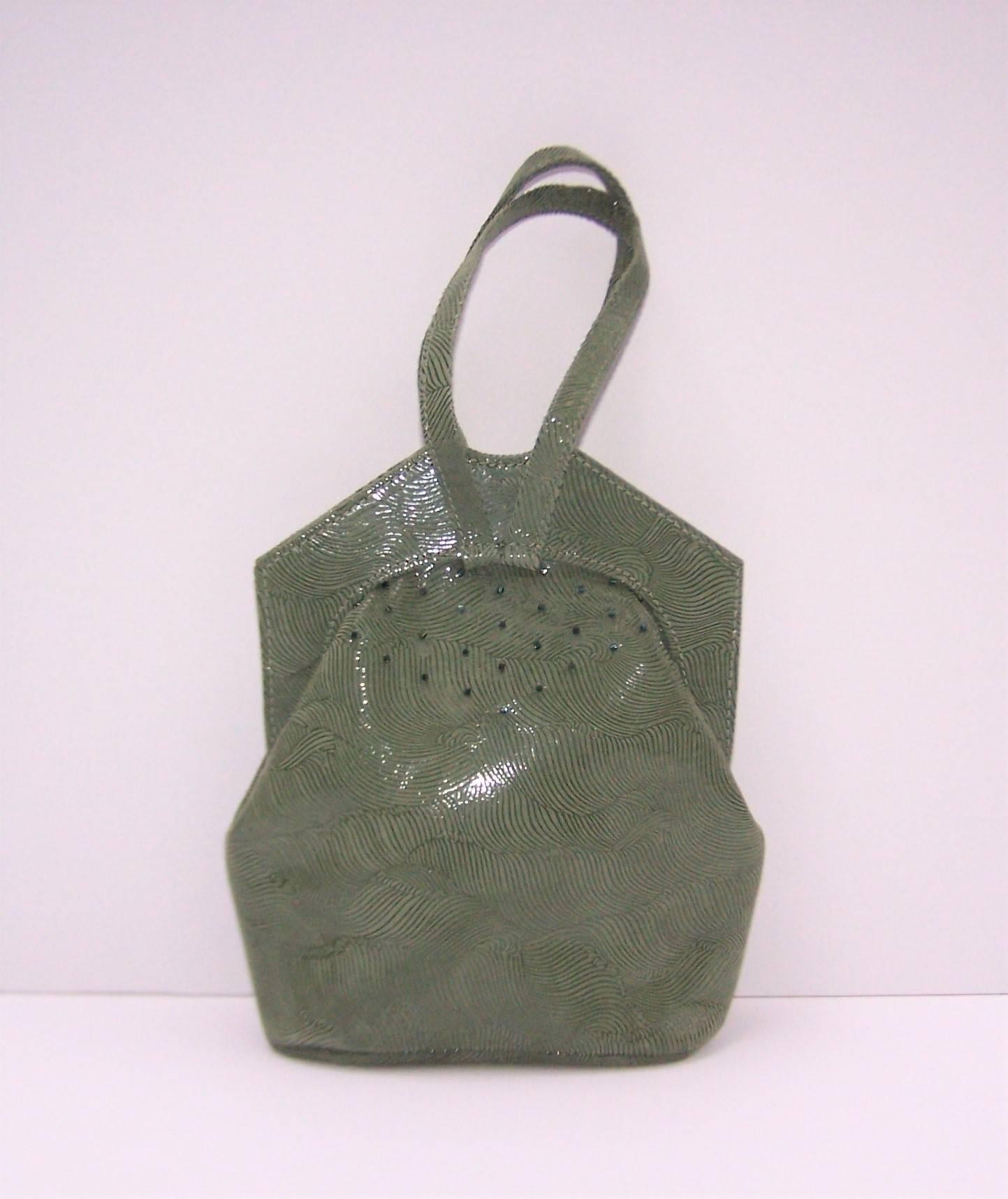 Michelle & Michael LaLonde create wearable art handbags featuring sophisticated design and unique details.  This sage green suede leather handbag is silk screen printed to create a design that catches the light and mimics a wave pattern.  The top of