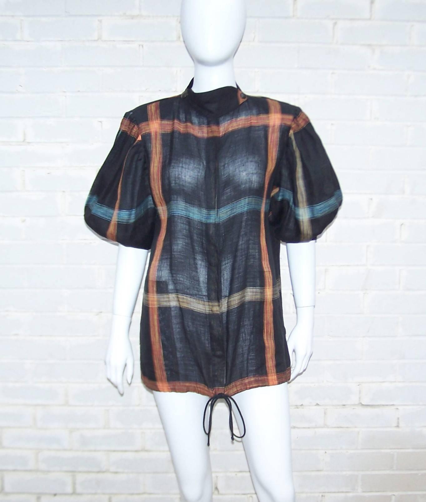 Krizia uses a vibrant windowpane flax linen fabric to create a comfortably stylish tunic top with interesting details including a crossover snap collar, faux drawstring hem and pleated puffed sleeves.  The black background of the fabric is accented
