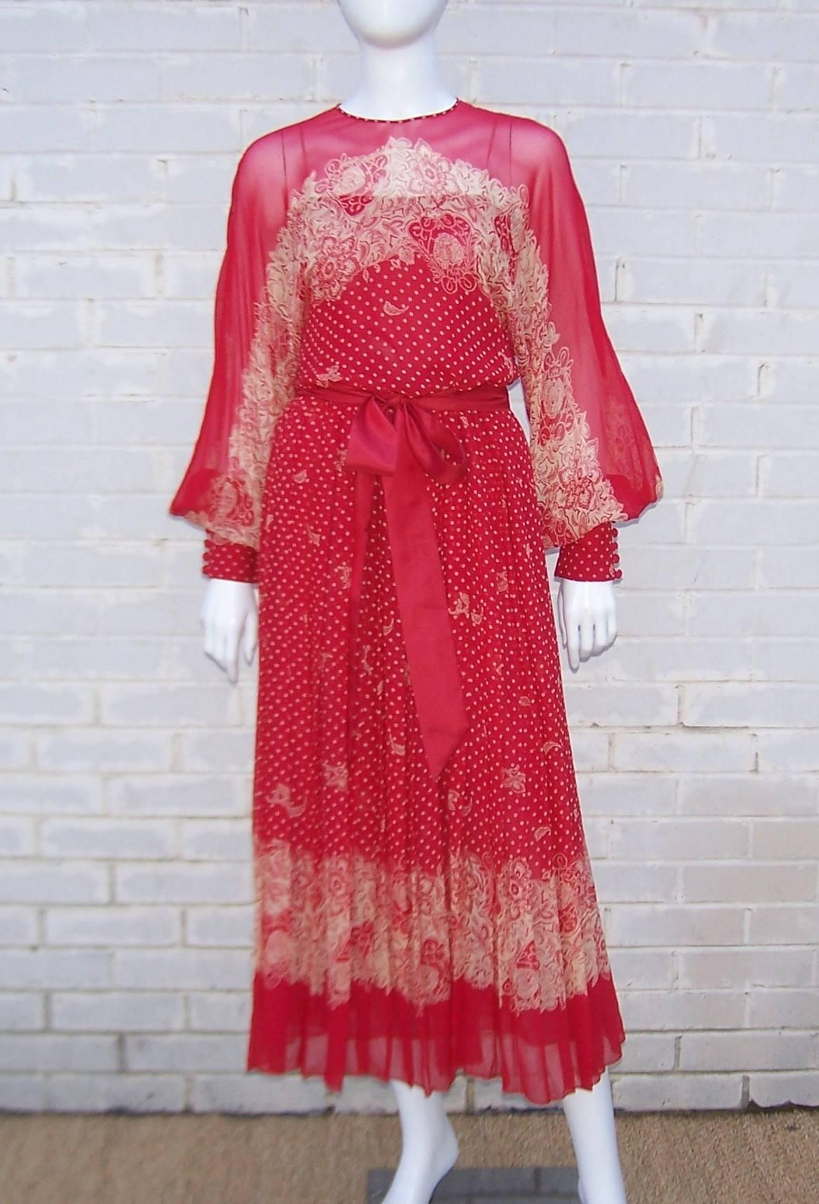 This lovely Adele Simpson design from the 1980's combines a sheer red silk chiffon with a dolman sleeved silhouette for an ethereal dress which can be worn for many different occasions.  The silk chiffon print incorporates polka dots and a trompe