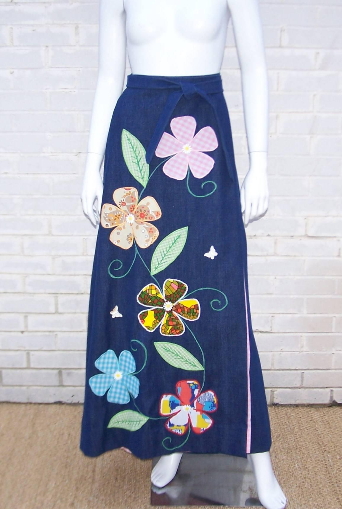 This C.1970 maxi wrap skirt is adorable.  The soft finish denim is embellished with floral appliques and stitching which adds color and texture to the design.  It is fully lined with a coordinating pink and white gingham which is cleverly repeated