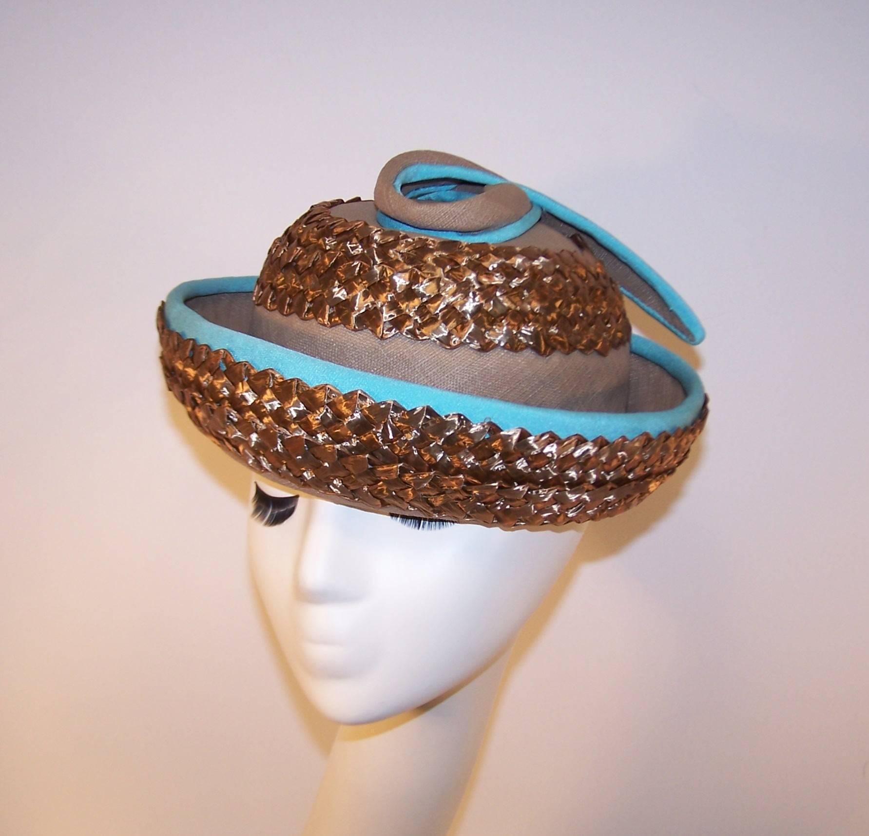 The color combination of this 1960's upturned boater hat by Bonta Creatrice is eye catching.  The natural light brown linen body is accented with a coordinating straw braid and set off with turquoise silk banding at the brim and on the decorative