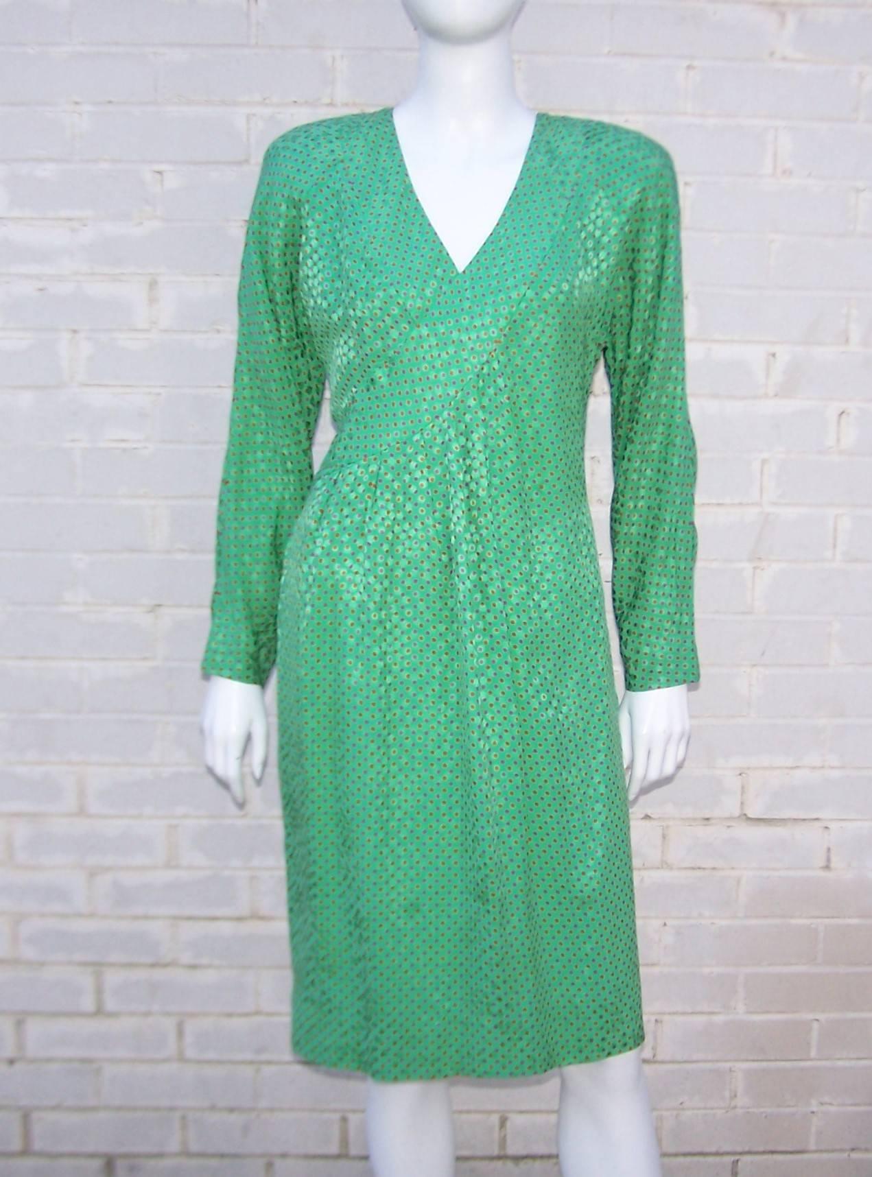 This 1980's dress by Japanese designer, Hanae Mori, is a vibrant combination of a shimmering green jacquard pattern embellished with fuchsia and orange polka dots.  Ms. Mori's special 'east-meets-west' blend of Japanese style details and Western
