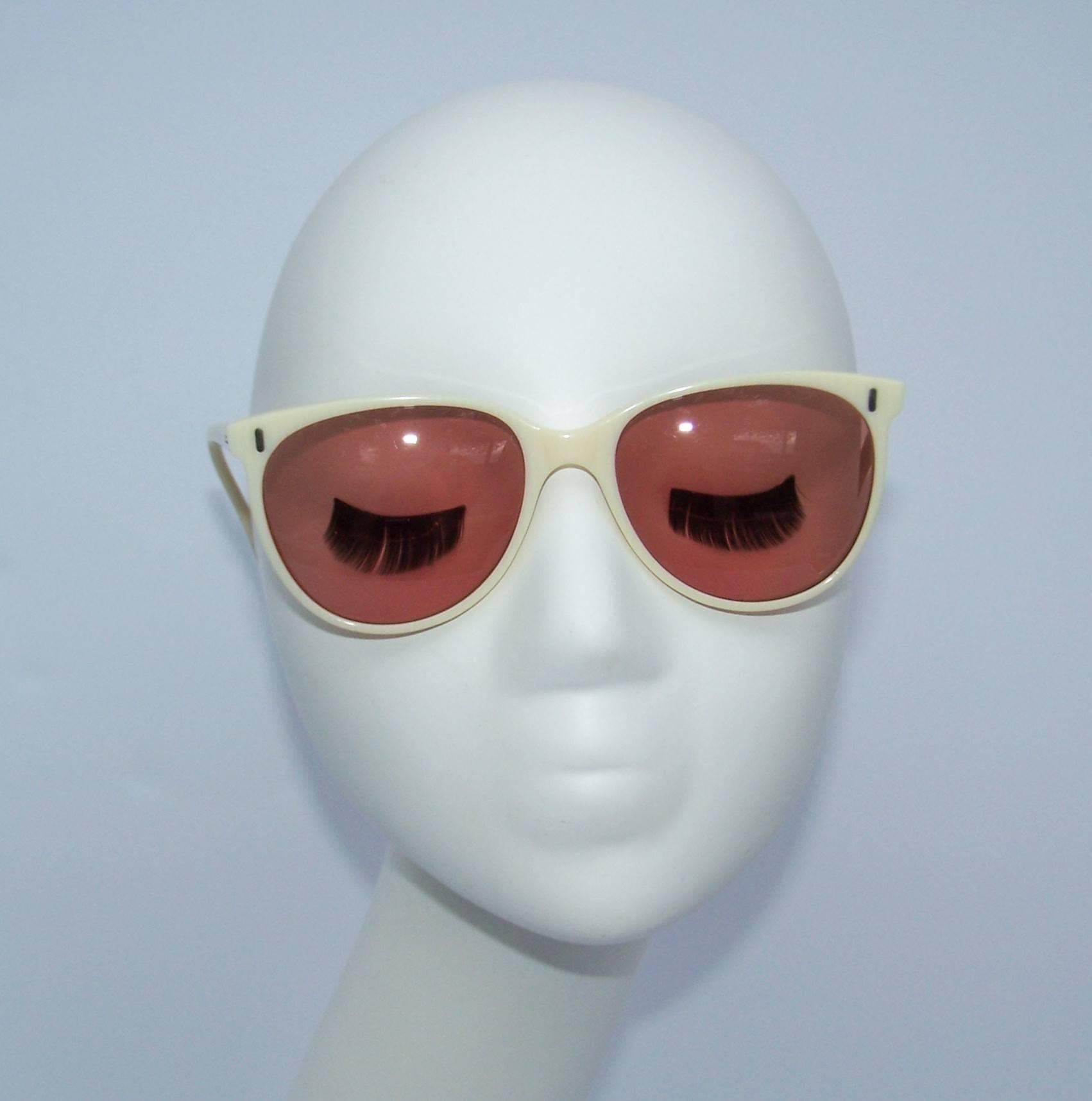 See the world through rose colored glasses with these vintage Calvin Klein sunglasses reminiscent of 1940's eyewear.  The off white frames feature a subtle striated design which lends them the appearance of old ivory.  The perfect accessory for your