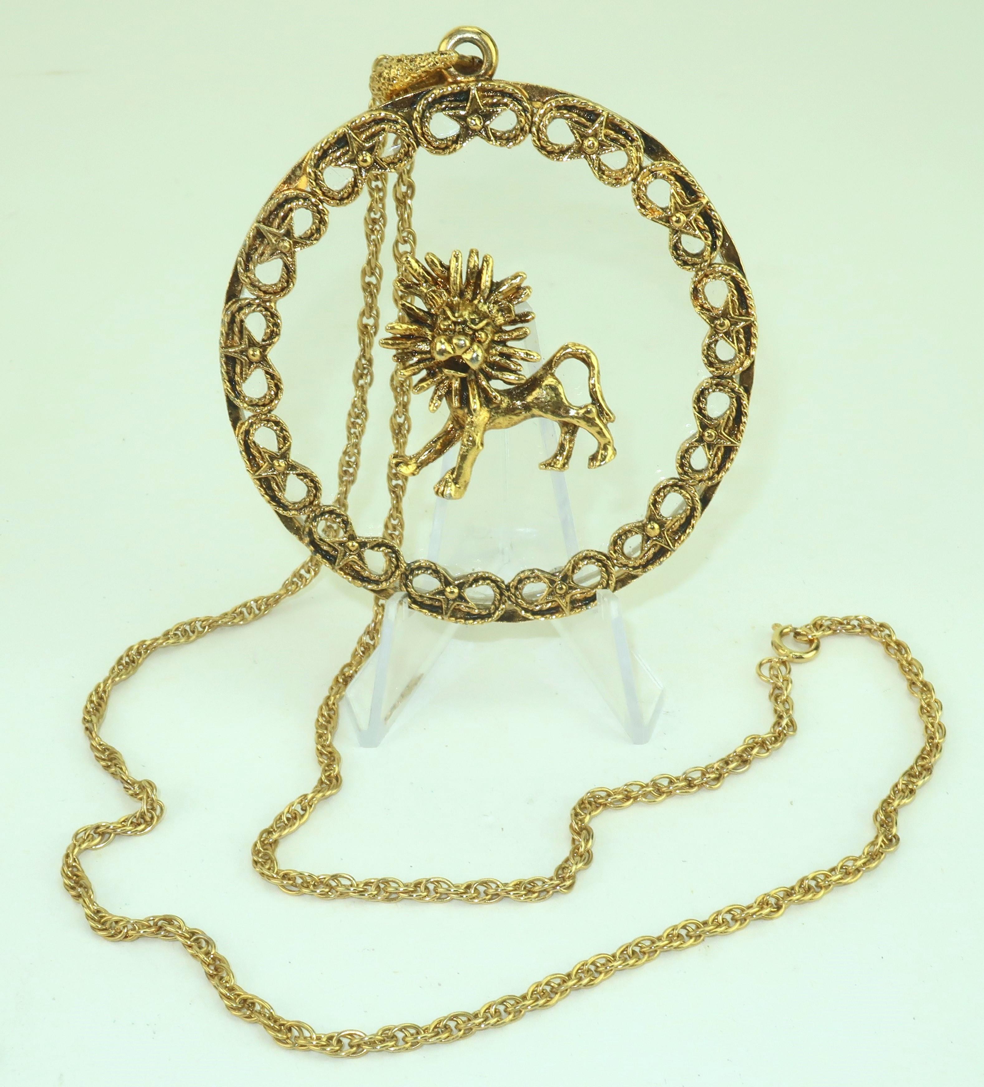 Démarquez-vous en véritable mode Léo avec ce collier pendentif Zodiac en métal doré des années 1960.  Le lion est attaché à du verre et semble flotter dans le grand pendentif rond.  Le pendentif est suspendu à une chaîne tressée munie d'un fermoir