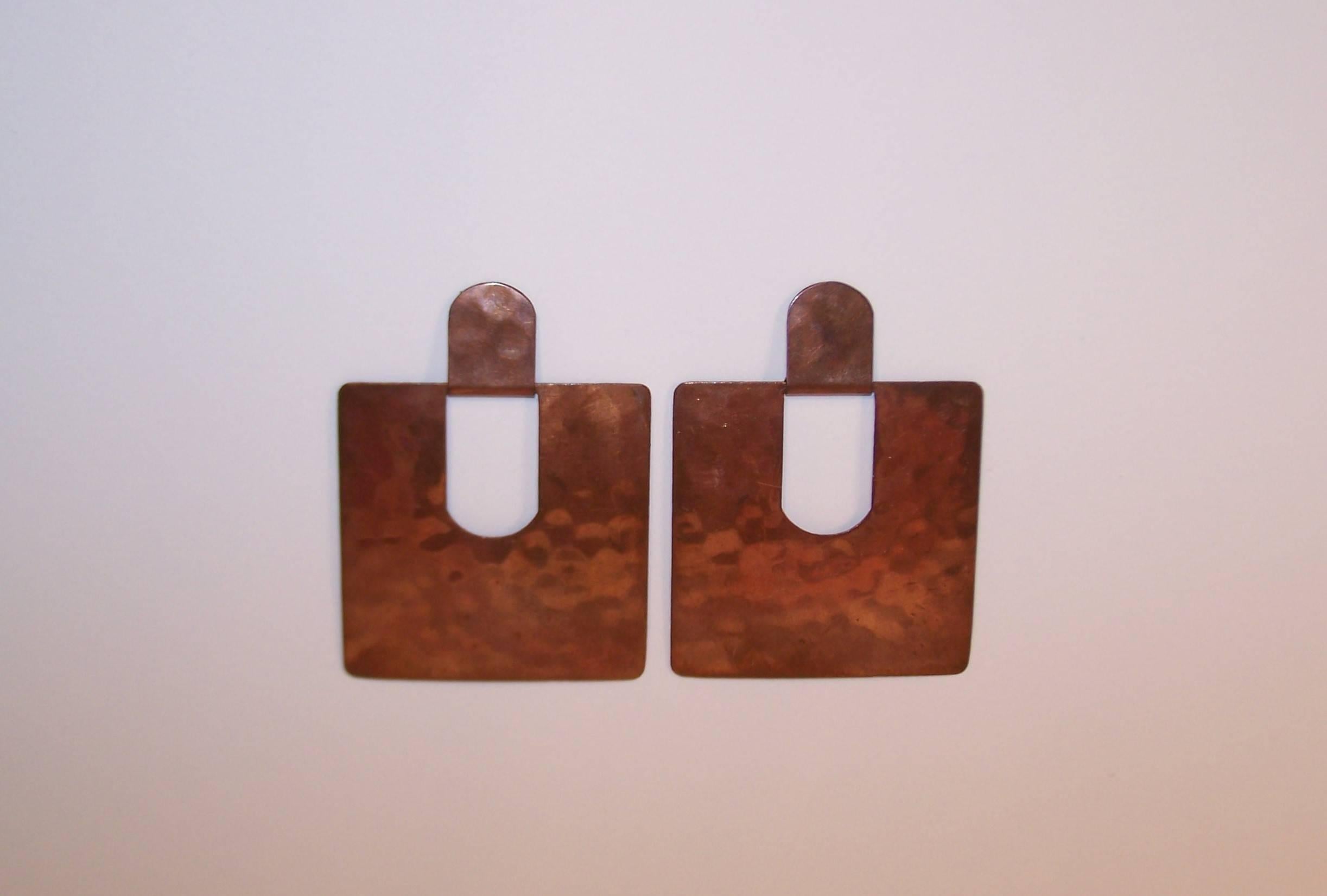 Love these earrings!  They are an amazing combination of modernist design and lightweight comfort.  The hand hammered flat copper components are hinged together in a doorknocker style providing a play on negative space.  They subtly swing back and