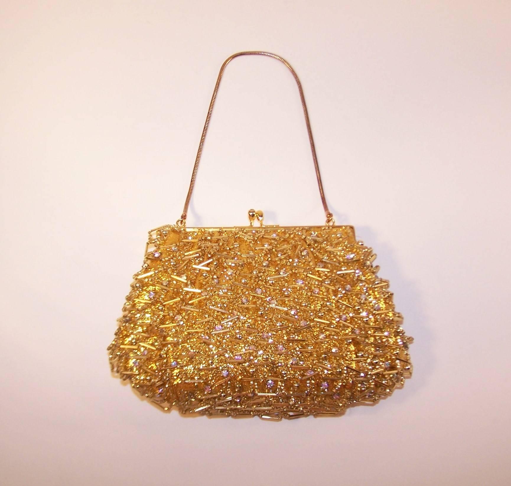 This adorable evening handbag by Magid has the golden touch.  The gold lame fabric body is embellished with looped beading, gold balls and aurora borealis style rhinestones.  The kiss lock closure opens to reveal a satin lined interior with a side