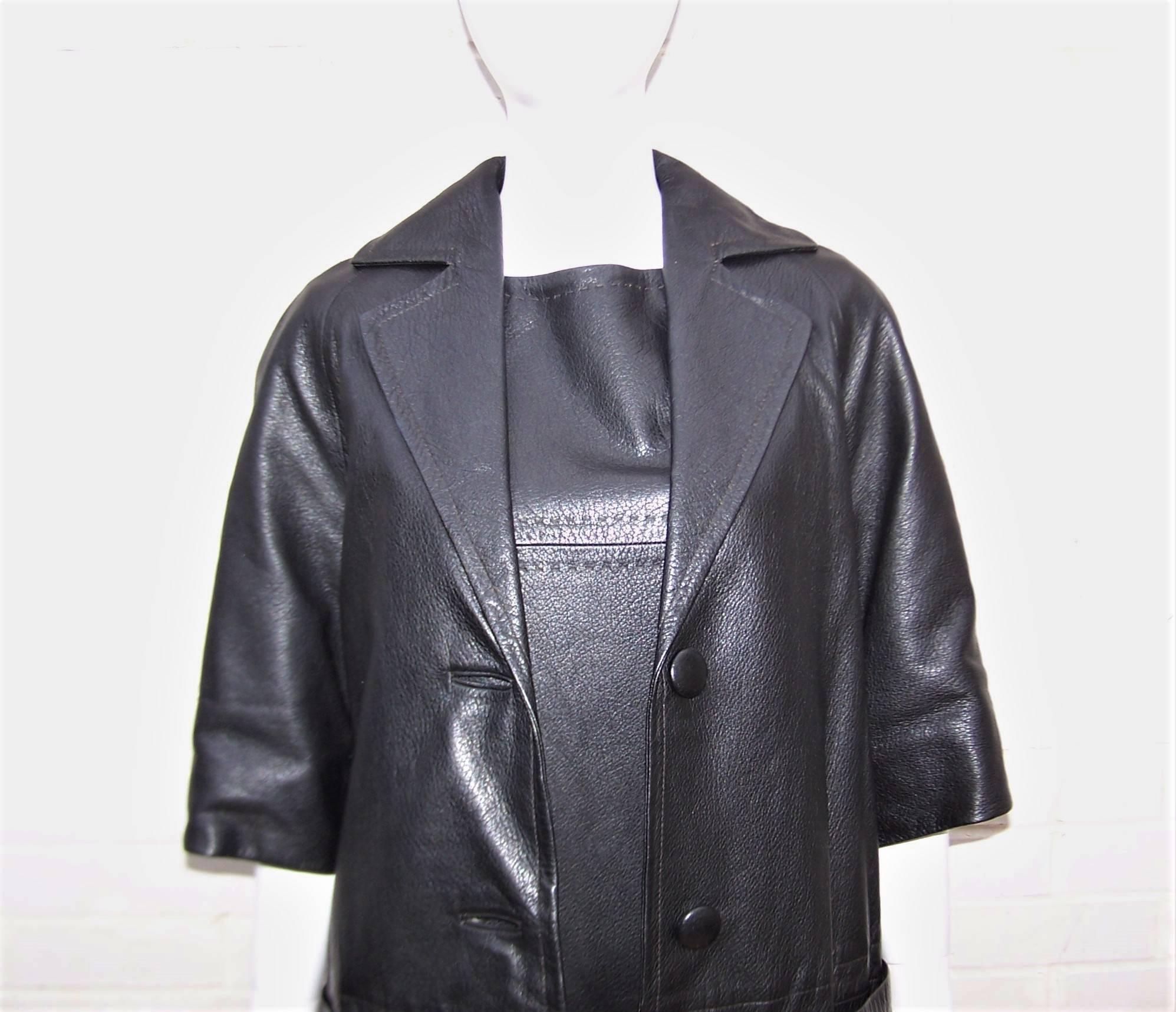 This mod 1960's black leather ensemble was made in Mexico for Real Sport.  The shift style jumper dress zips at the side with an optional coordinating belt and is accompanied by a jacket with bell shaped 3/4 sleeves.  Both pieces have detailed