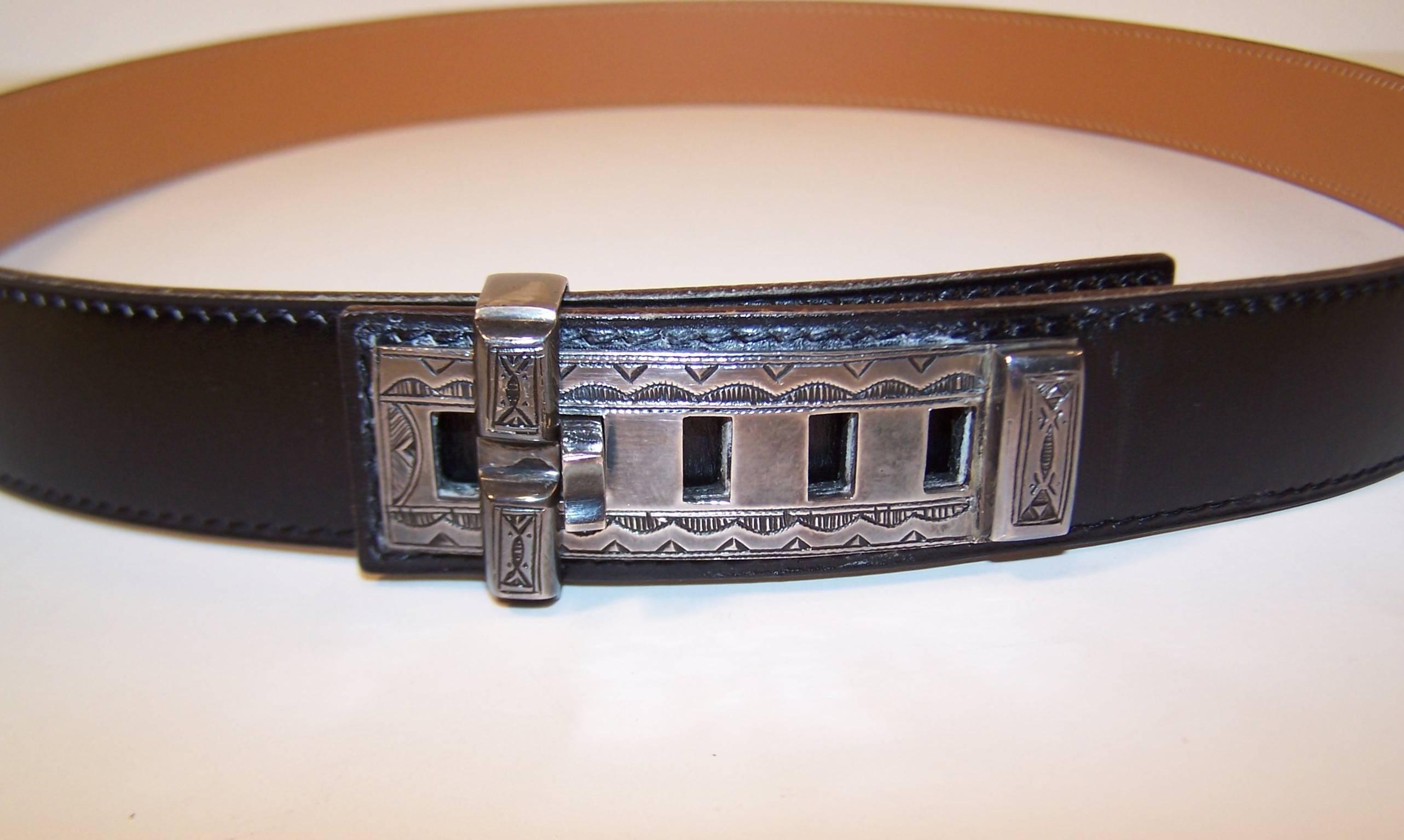 This unique Hermes 'Touareg' black leather belt features a hand crafted sterling silver buckle with a North African tribal motif.  The closure is a 'collier de chien' style with five adjustments and a sliding bar to keep everything in place.  The