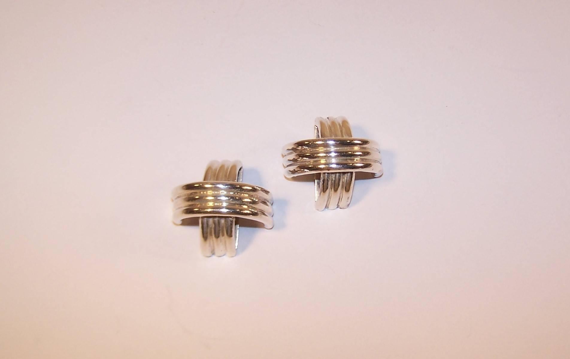 These 1980's sterling silver earrings from Ture have a machine age industrial quality to the design.  Each earring features three tubular bands in a crescent shape arching over another set of bands.  The overall effect is sculptural and stylish. 