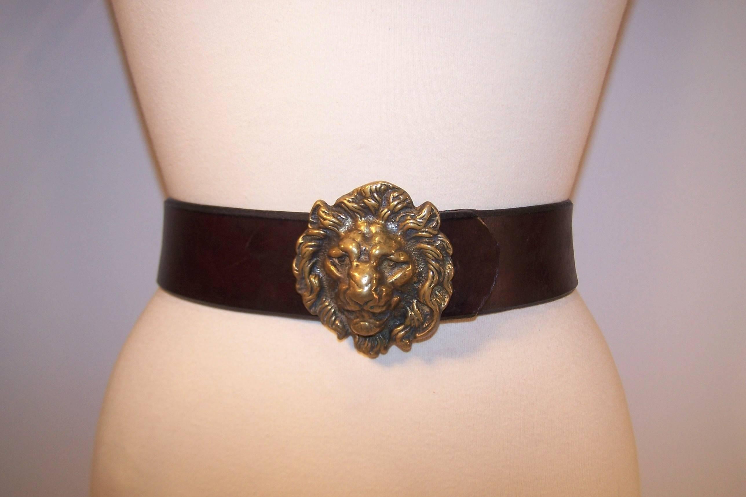 The stately antiqued brass lion buckle is the perfect foil for this thick brown saddle leather belt.  The buckle is marked England on the back and has a hook which securely fits into four adjustable options on the belt.  Both a combination of
