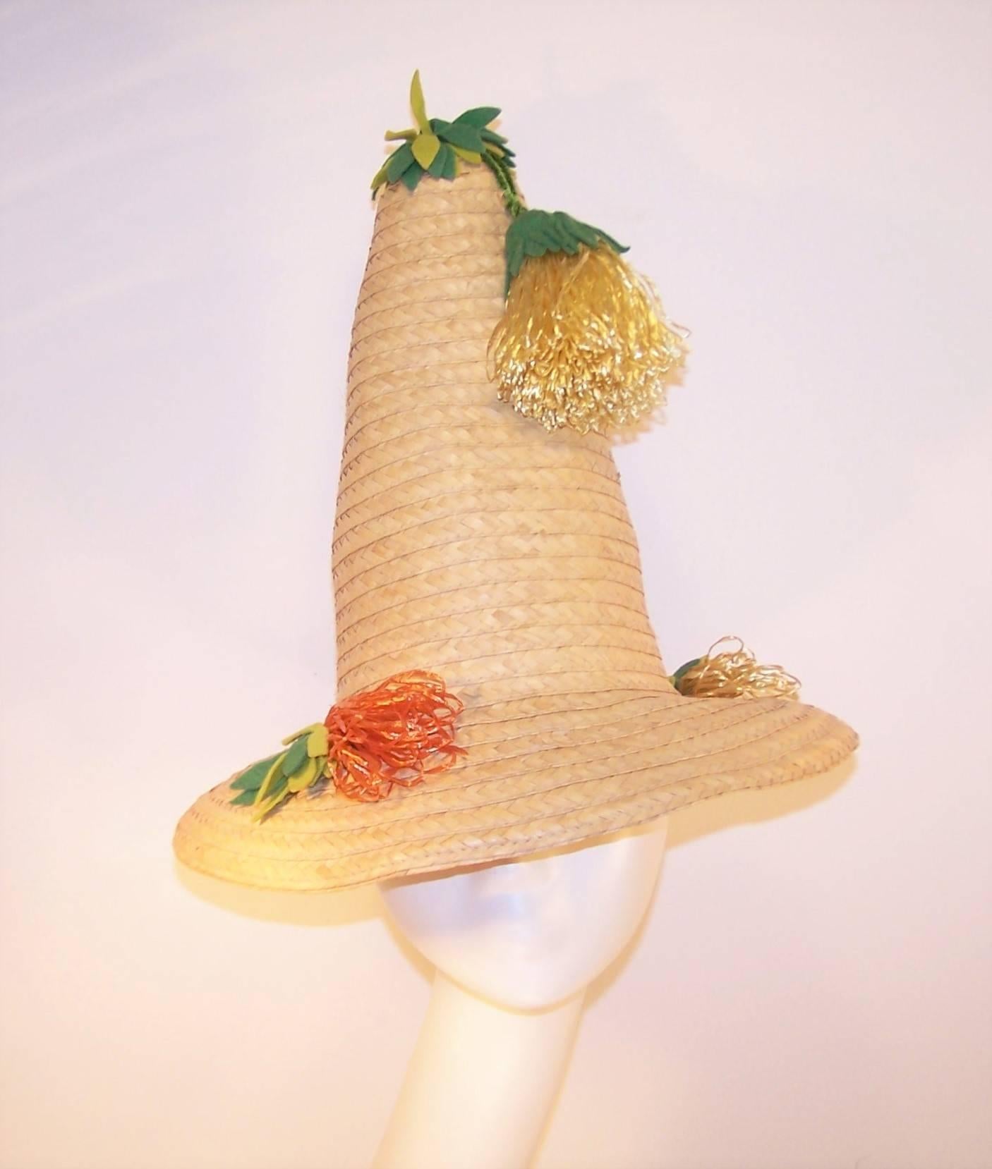 You'll be the life of the party when you show up with this whimsical 1950's straw hat.  The exaggerated conical shape is decorated with green felt leaves and synthetic grass flowers in yellow and orange.  A whole lotta pool side fun!  Excellent