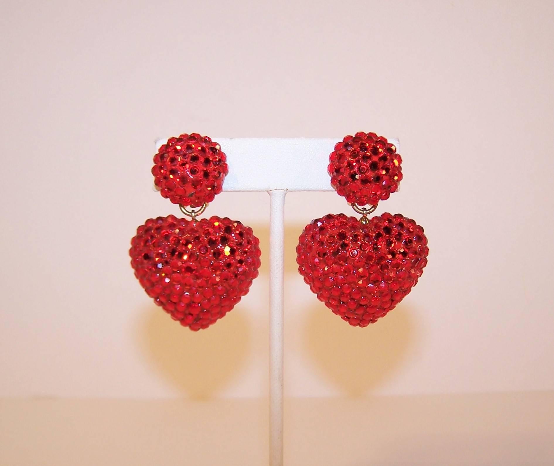 Ruby red perfection!  These 1980's Richard Kerr earrings are mesmerizing.  The heart shaped clip on danglers are fully encrusted in pave crystals that catch the light at every turn.  Each earring measures 2" long x 1.25" at widest point x
