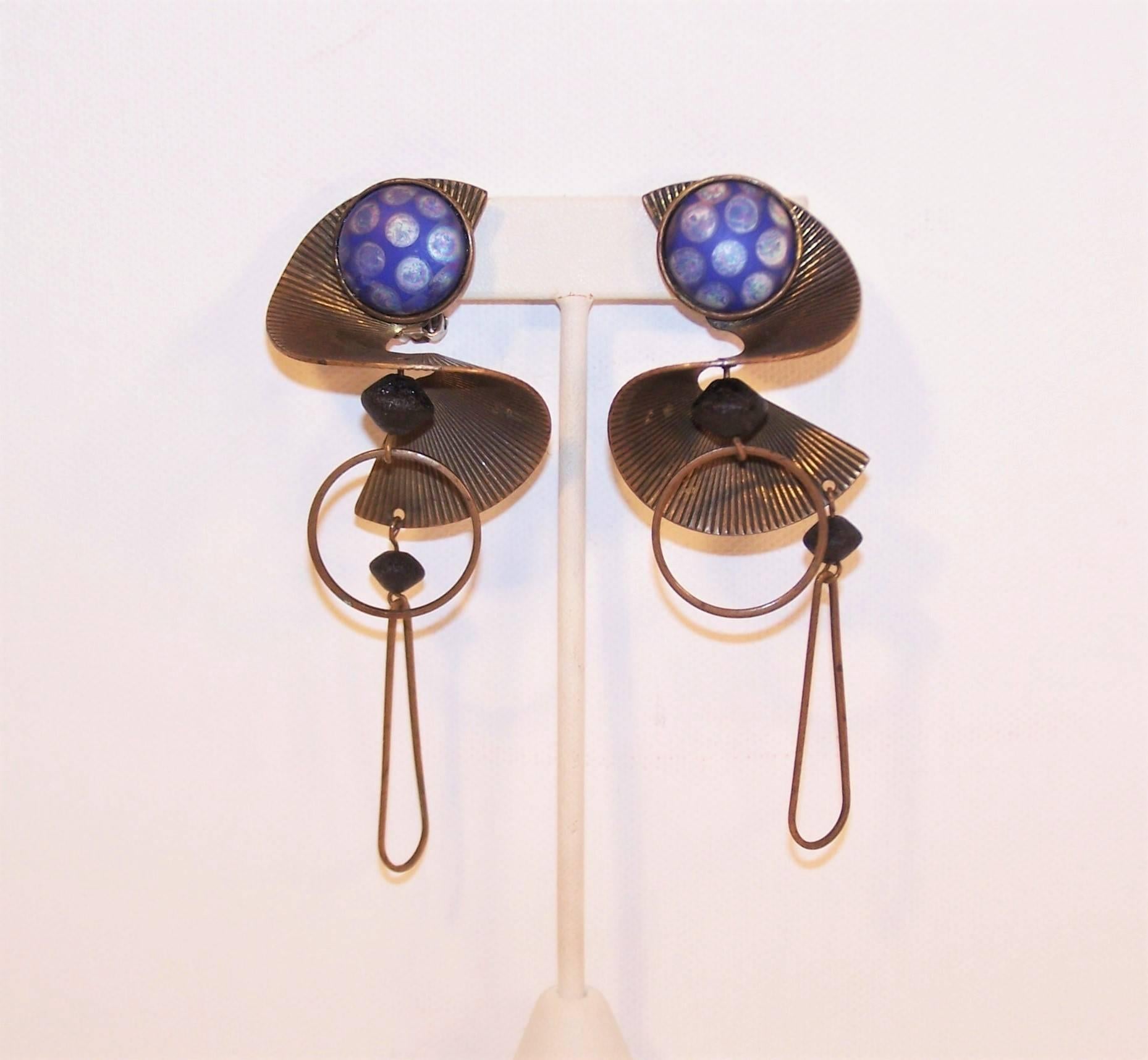 The stars and planets unite in these vintage artisan made earrings that conjure up celestial imagery utilizing blue art glass, copper and volcanic style black ceramic beads.  The clip on base is a swirled striated copper which suspends two