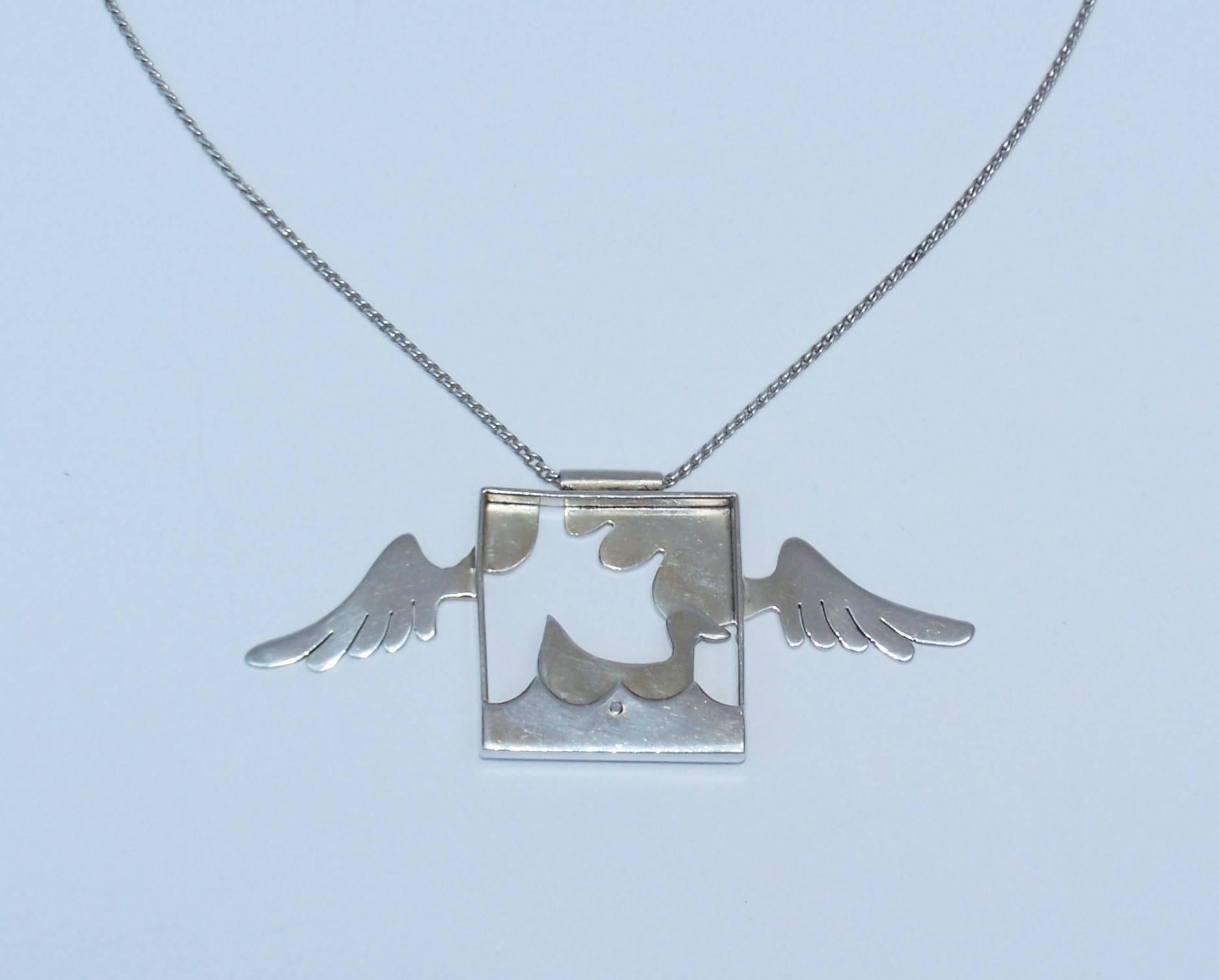 This 1970's sterling silver necklace combines whimsical articulated motion with surreal imagery to create a fun piece of fashion jewelry.  The 3-D style 3.5" x 1.38" pendant features a framed duck floating on water with a hinged joint
