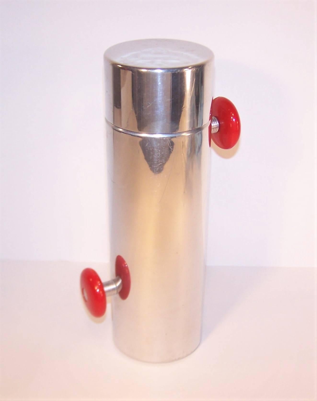 Get your party started with this 1930's Kromex 'Konga' polished aluminum cocktail shaker. The sleek art deco design includes two red plastic rotating knobs that enable the mixologist to roll the shaker in a konga-like motion. The body of the shaker