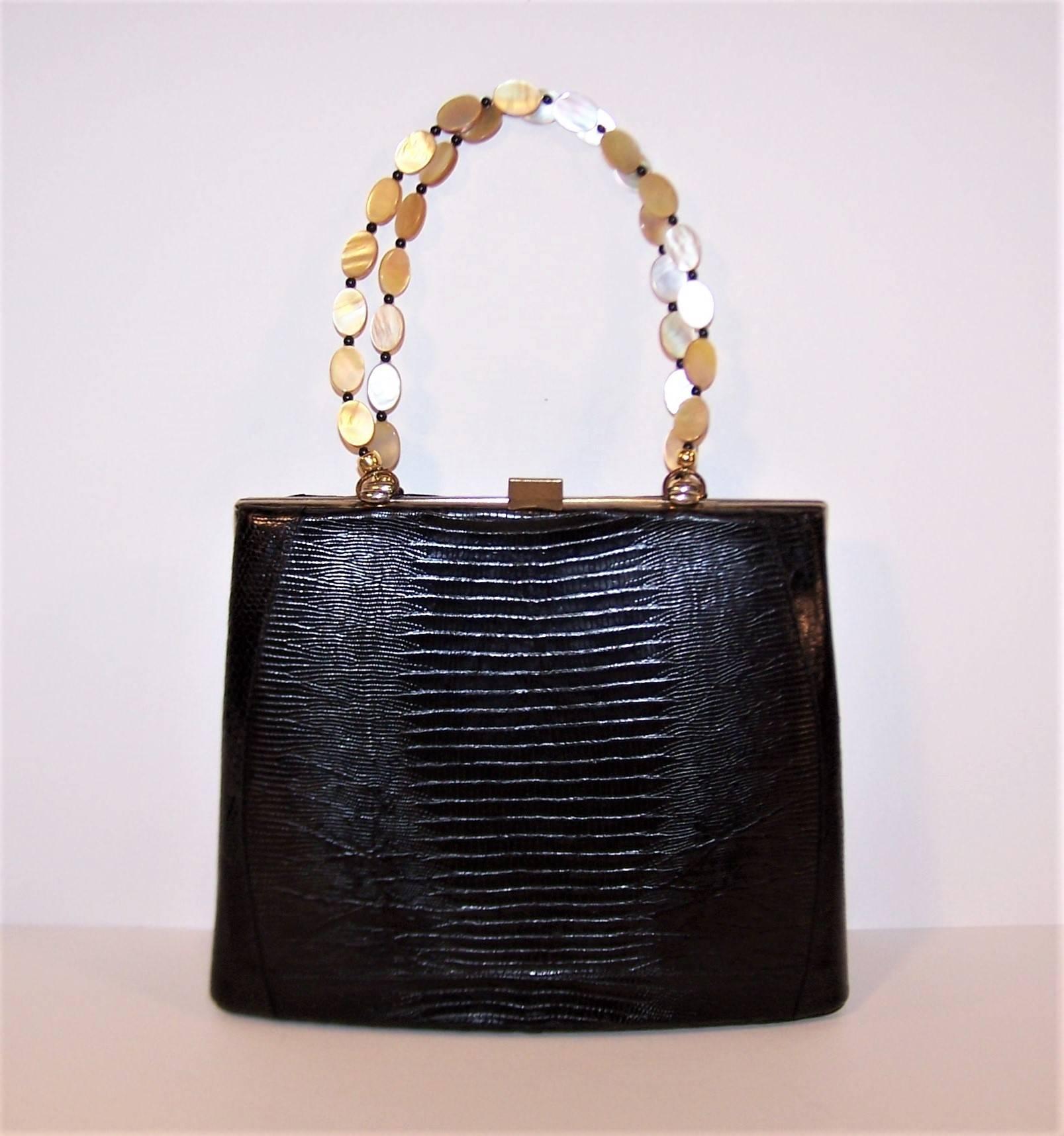 Poetic license has been taken with this handsome black snakeskin handbag by Sydney of California in the form of a replaced handle and the results are as smooth as a sonnet.  The double handles are formed from polished mother-of-pearl ovals