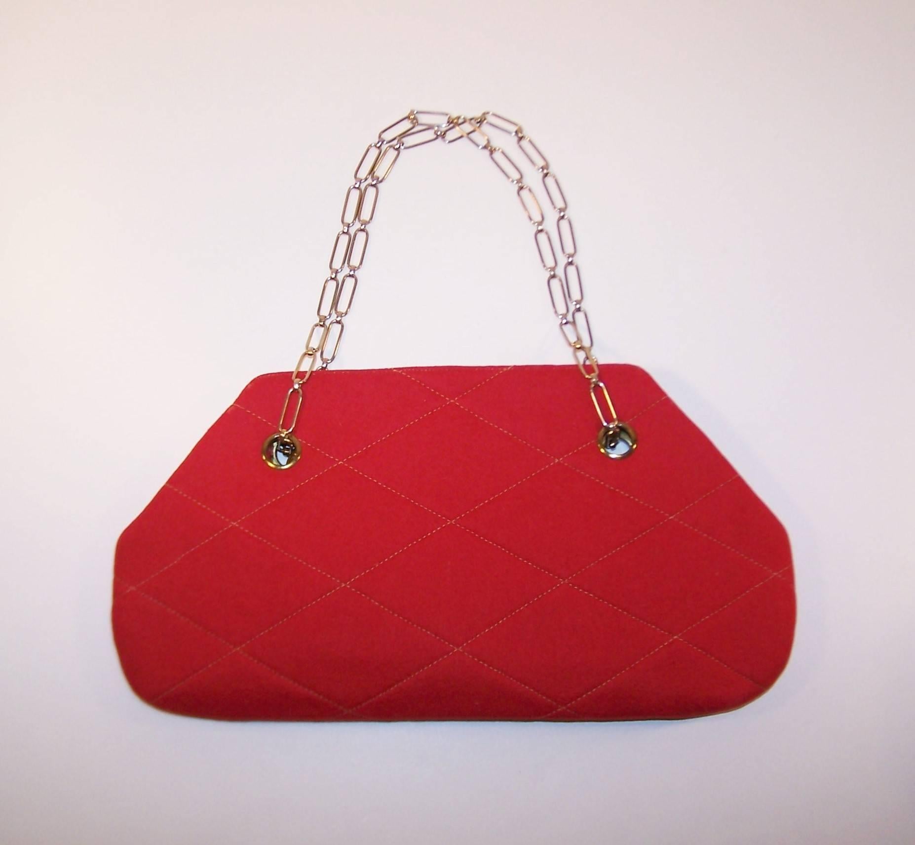 Stylish texture with mod bells and whistles!  This 1960's handbag features an envelope shape in a red wool quilted body with complimentary striped interior and a clever chain handle which converts from short to long.  The thin silhouette easily