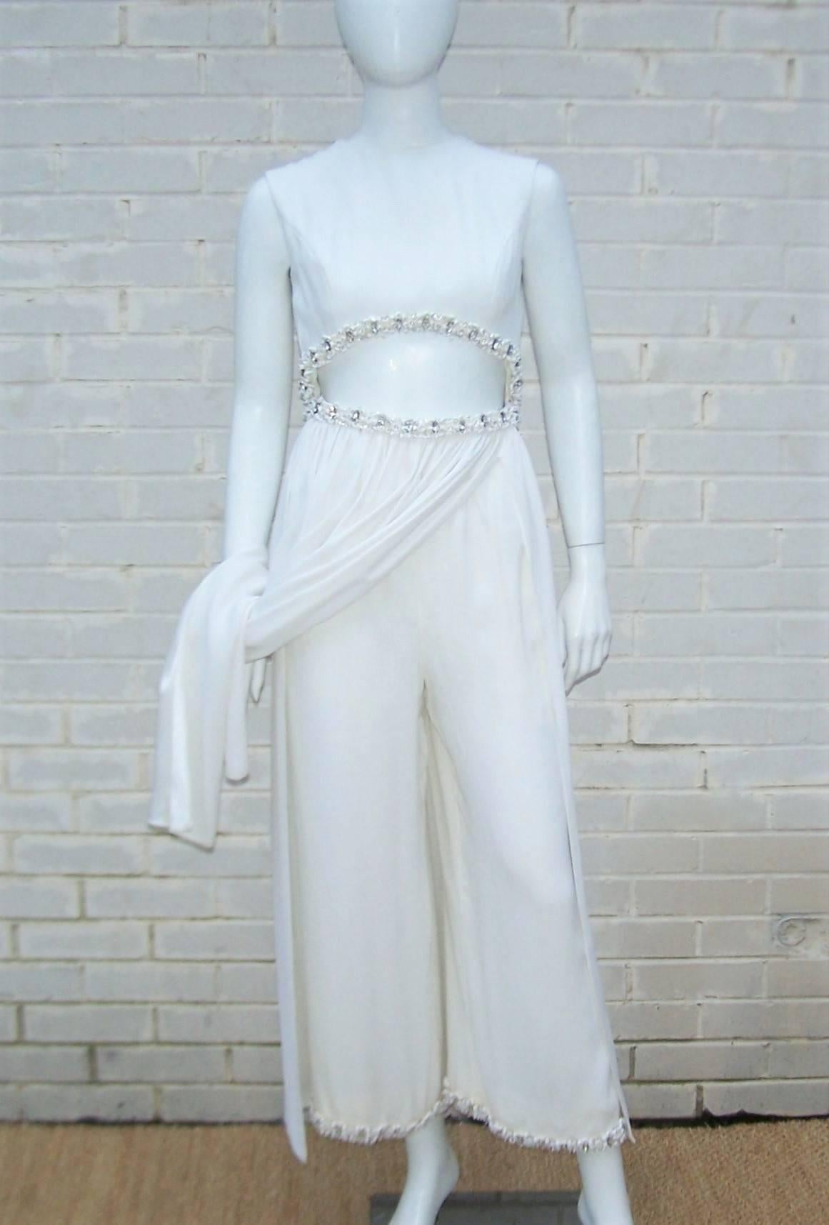 This fabulous design from Elinor Simmons for Malcolm Starr is a combination of 'I Dream of Jeannie' meets 1970's disco glamour.  The midriff baring silhouette appears to be two pieces from the front but is actually a one piece jumpsuit with a front