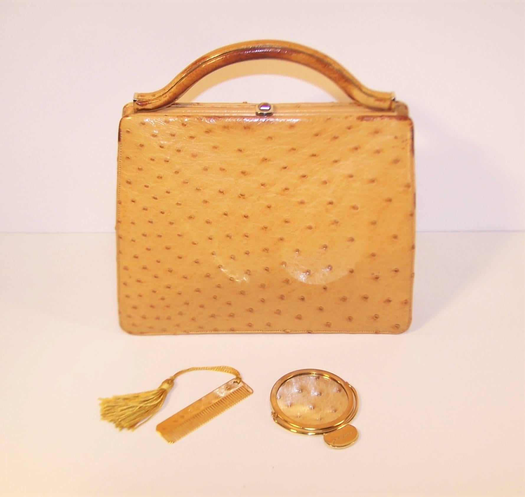 Lovely and ladylike!  This Judith Leiber ostrich skin handbag is a neutral light camel shade that promises to go with everything.  The structured top handle yields to a drop in shoulder strap with one click of the tiger's eye embellished snap