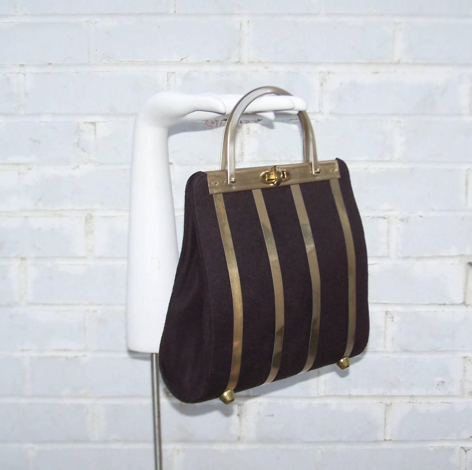 A little space age style with a ladylike sensibility makes for a fun combination in this unique Stylecraft of Miami handbag.  The brown wool body is caged in gold tone aluminum bands which bow out in the front and swoop in at the back.  The metal