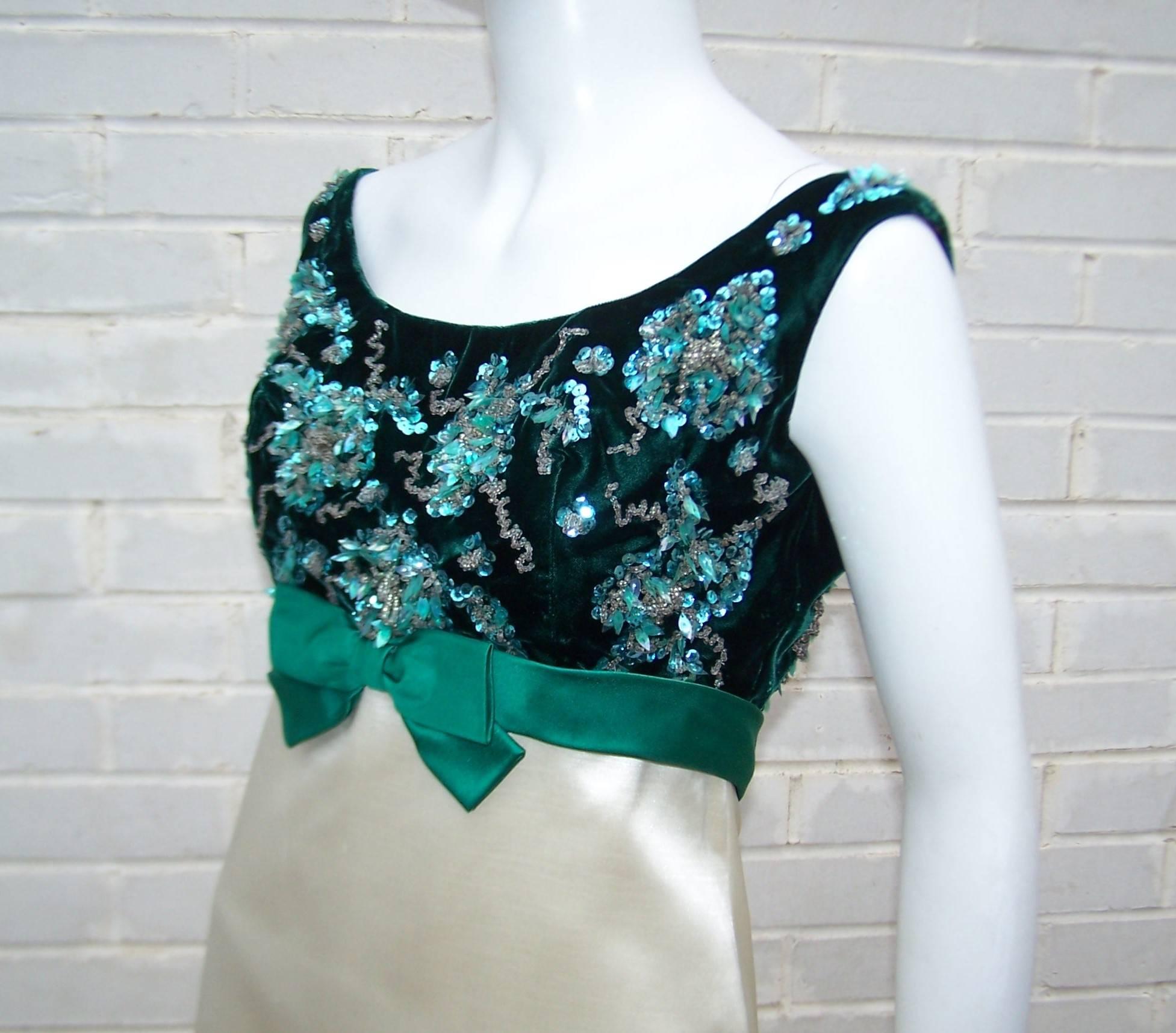 This 1960's evening dress conjures up images of Jackie Kennedy era class and glamour.  The sleeveless empire waist silhouette features a emerald green velvet bodice embellished with aqua green sequins and palettes finished with a satin bow and