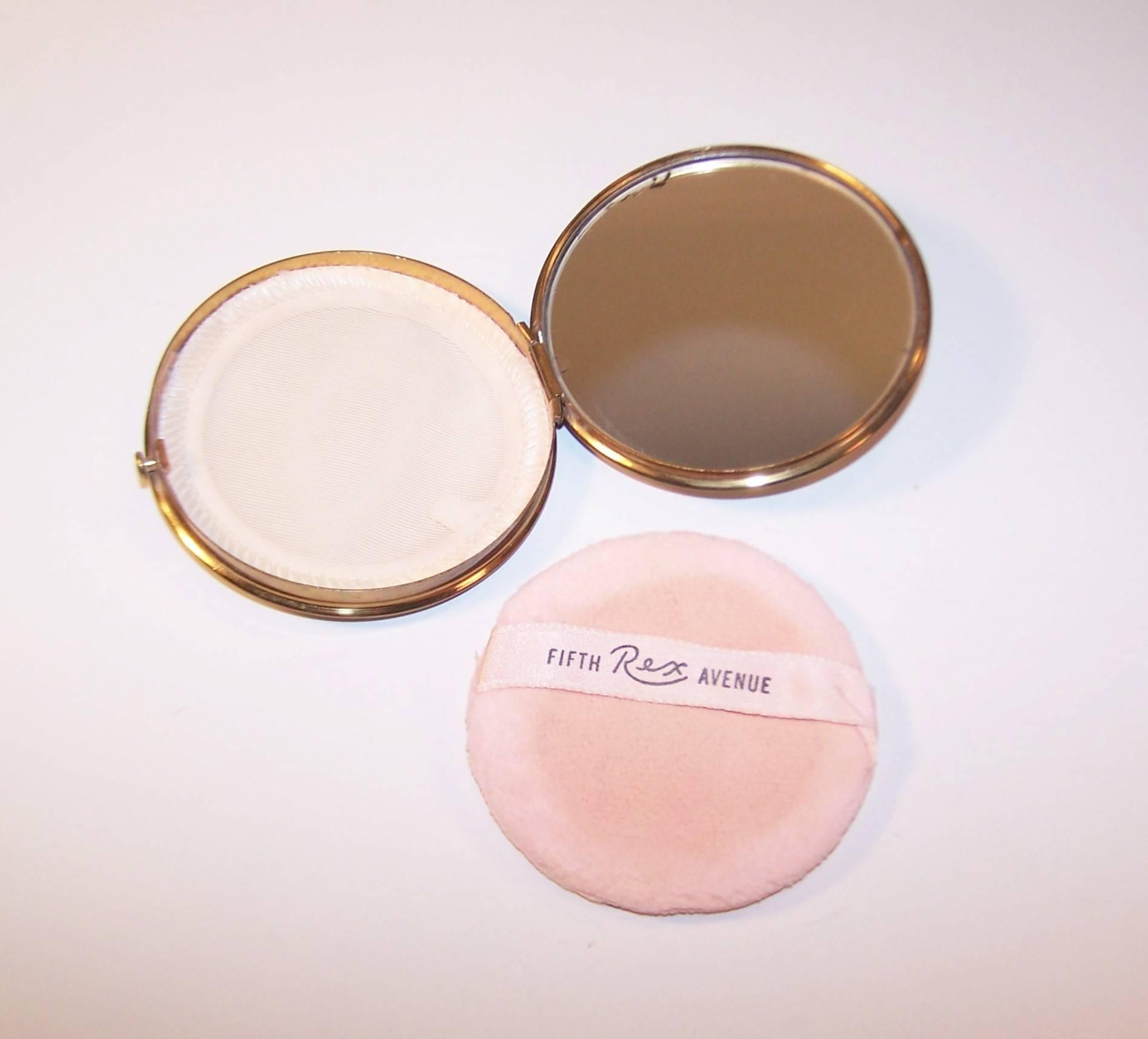 Rex Fifth Avenue was notably famous for utilizing colors in their designs.  This 1950's confectionery mirrored powder compact is a whimsical example of their work with a fabric decorated lid featuring silk satin stripes in pastel shades worthy of a